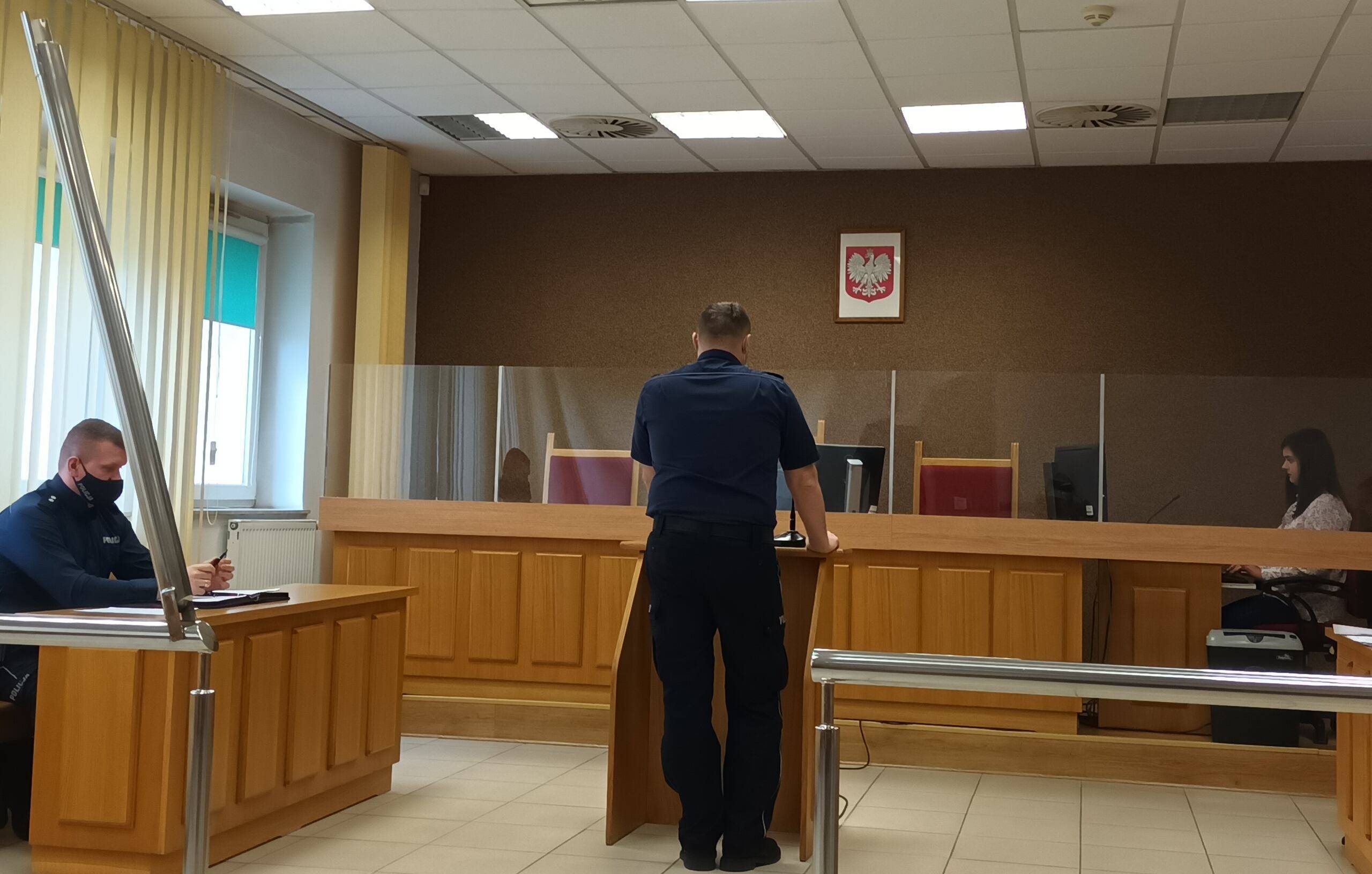 Mężczyzna w policyjnej koszuli zeznaje przed sądem jako świadek