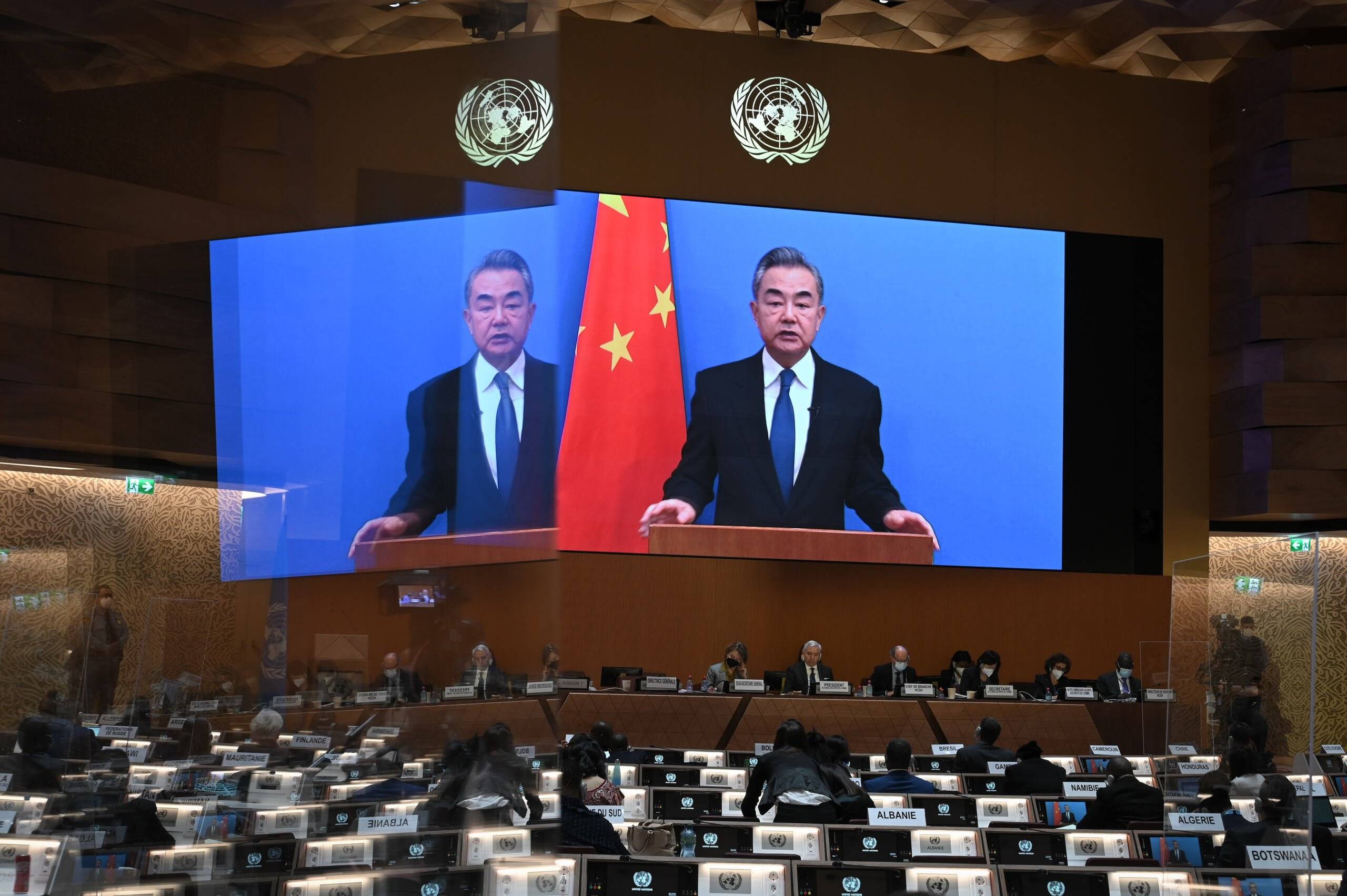 Szef chińskiego MSZ Wang Yi na ekranie przemawia w ONZ, obok chińska flaga