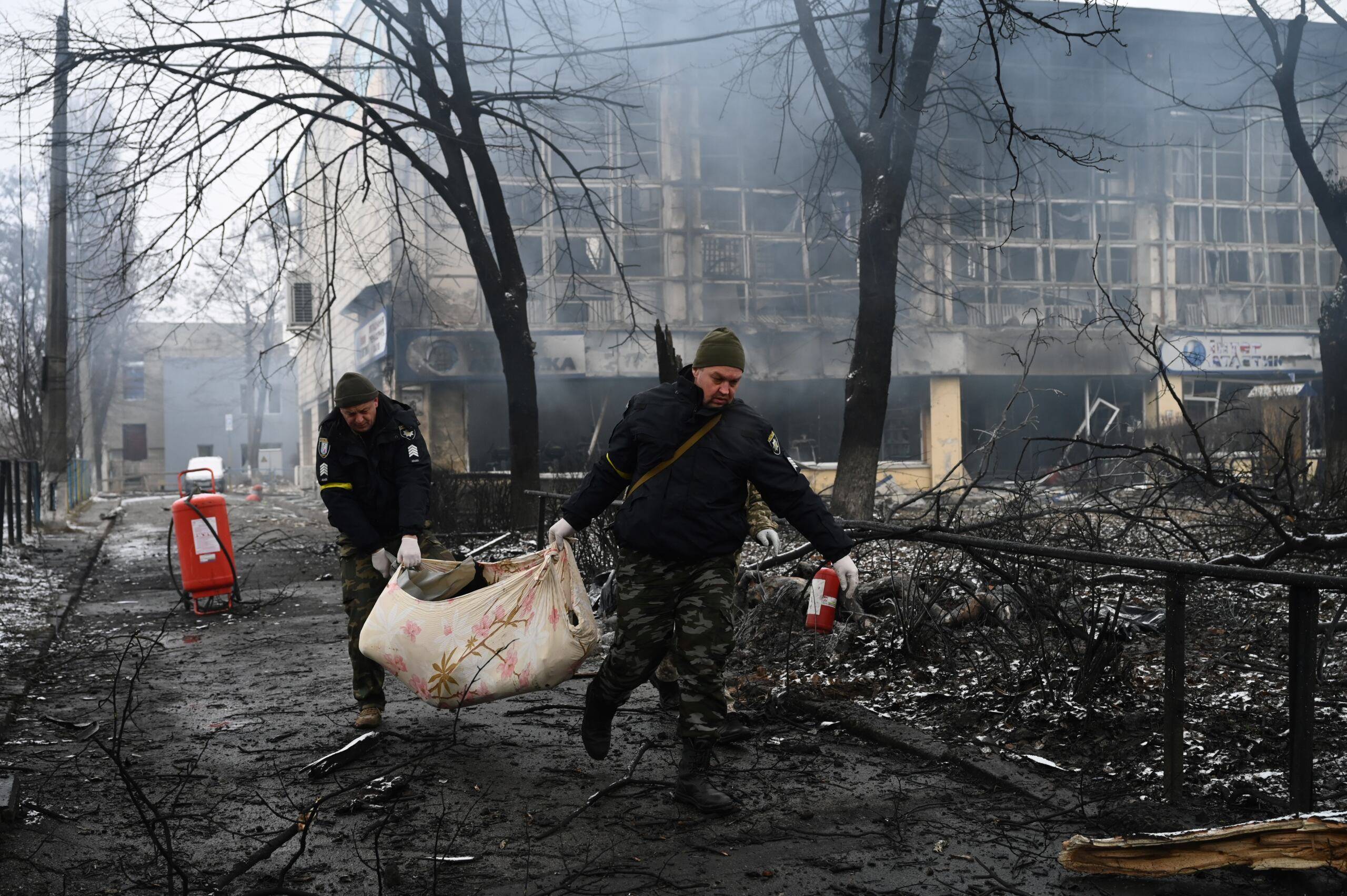 Ukraina, Kijów, 02.03.2022. Policjanci wynoszą ciało osoby, która zginęła podczas wybuchu wieży telewizyjnej