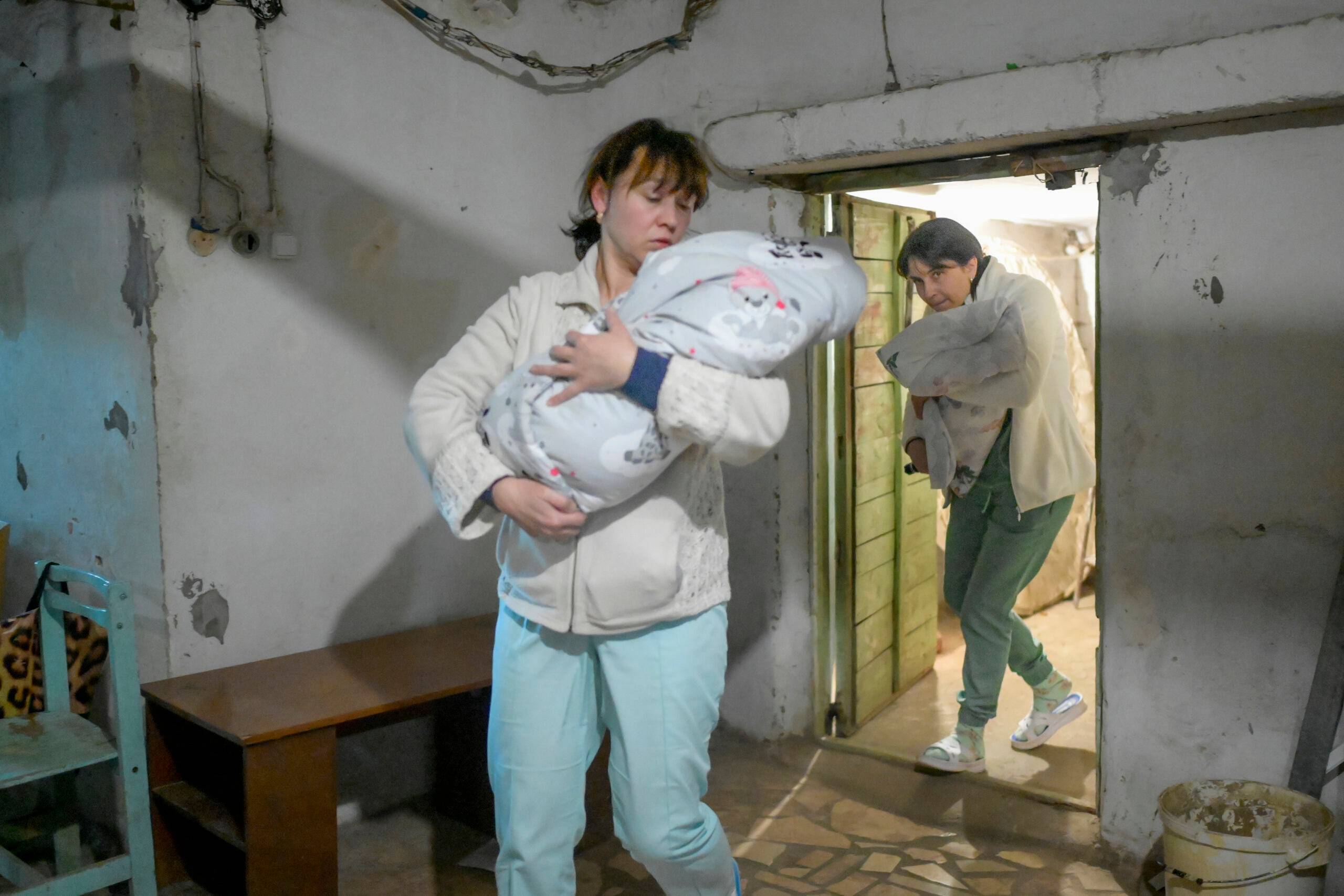Nurses carry babies to the basement of maternity hospital as sirens warning for air raids in Mykolaiv, on March 14, 2022. - Almost half of the 49 women have had to give birth in the basement since 24 February. Mykolaïv is the scene of violent clashes, as Russian troops want to break down this last lock before the large port of Odessa, 130 km further west on the Black Sea. (Photo by BULENT KILIC / AFP)
