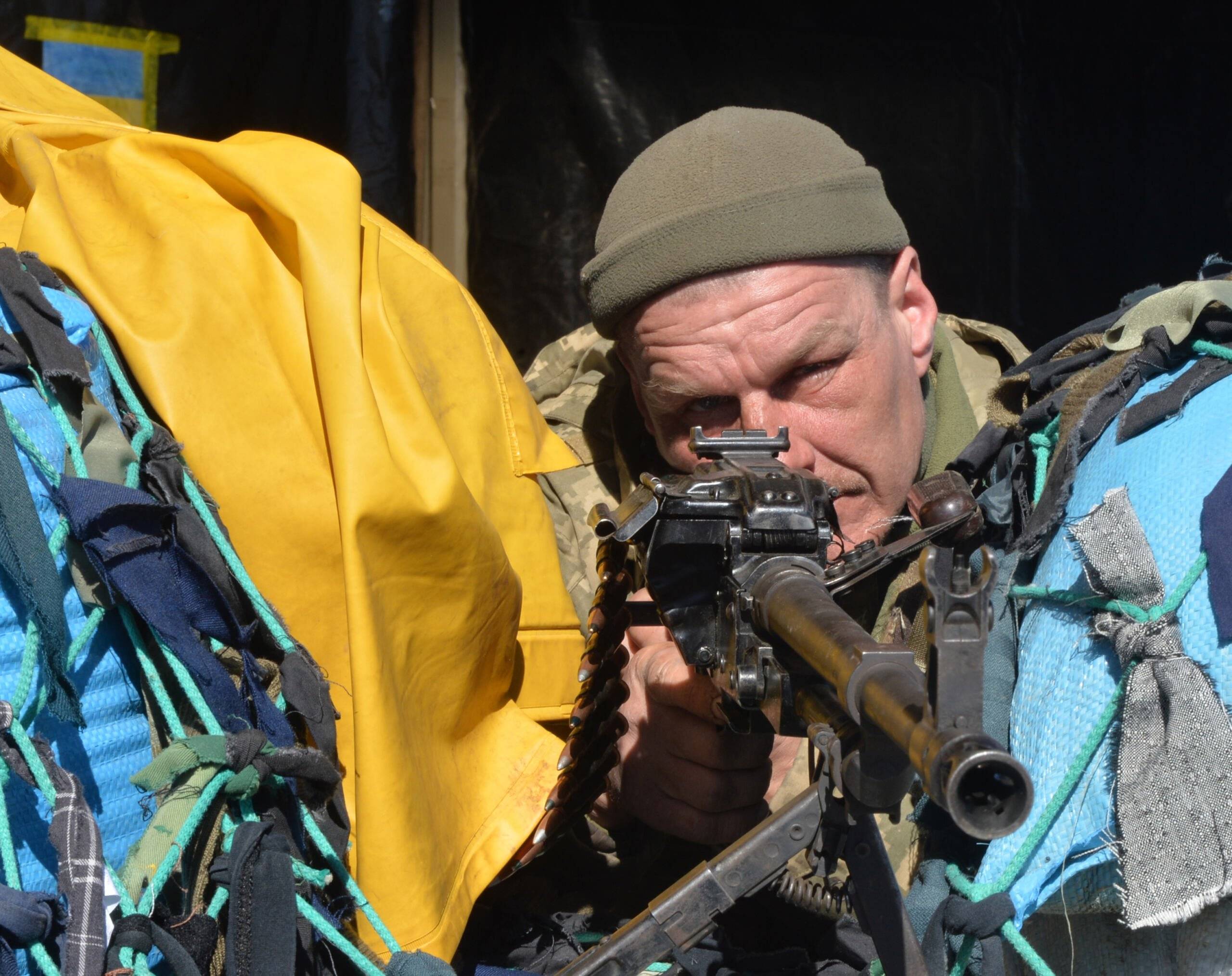 Ukraiński żołnierz celuje z broni na checkpoincie w Charkowie