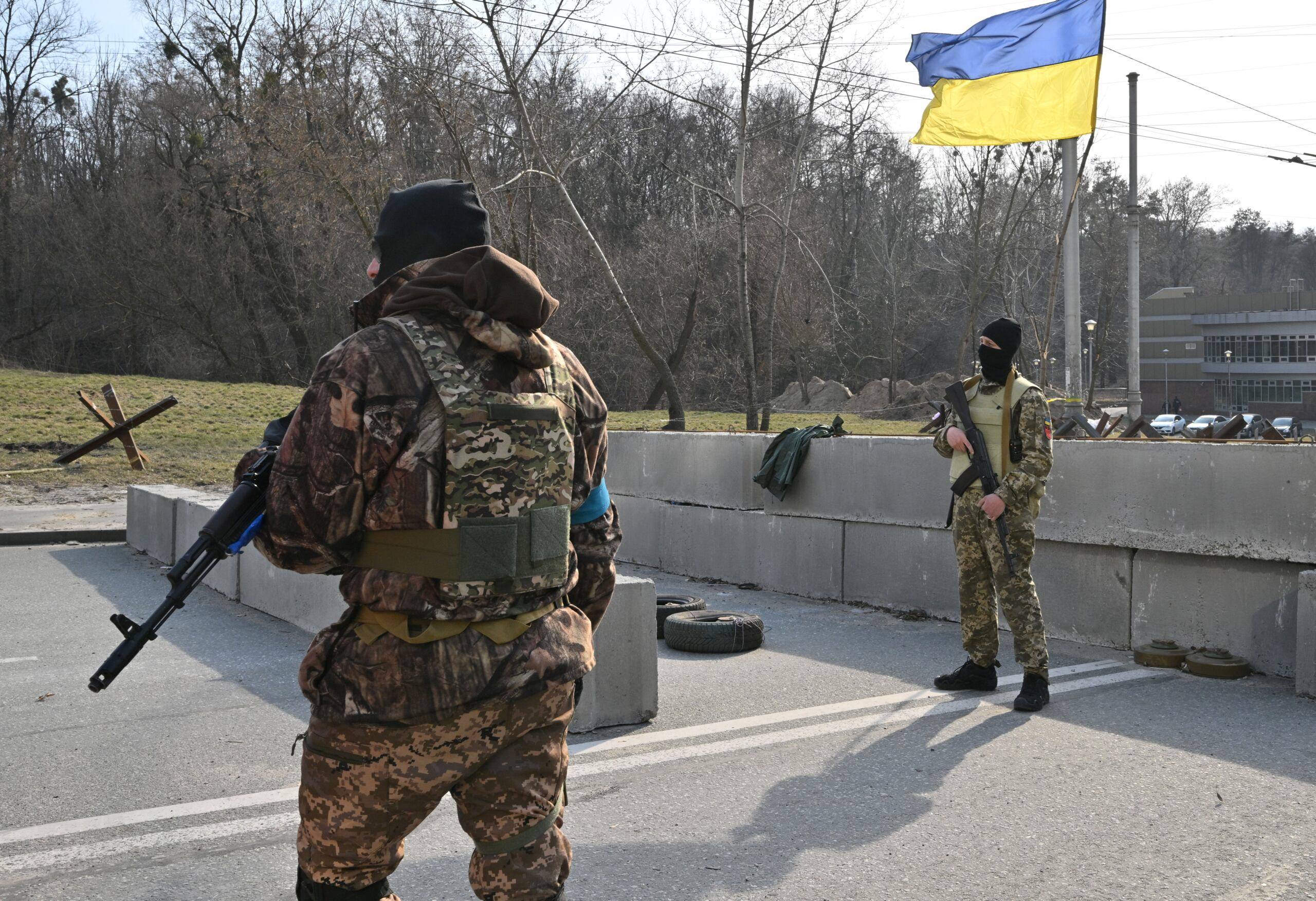 Ukrainian soldiers stand guard at a checkpoint in the outskirt of Kyiv on March 28, 2022. (Photo by Sergei SUPINSKY / AFP)
