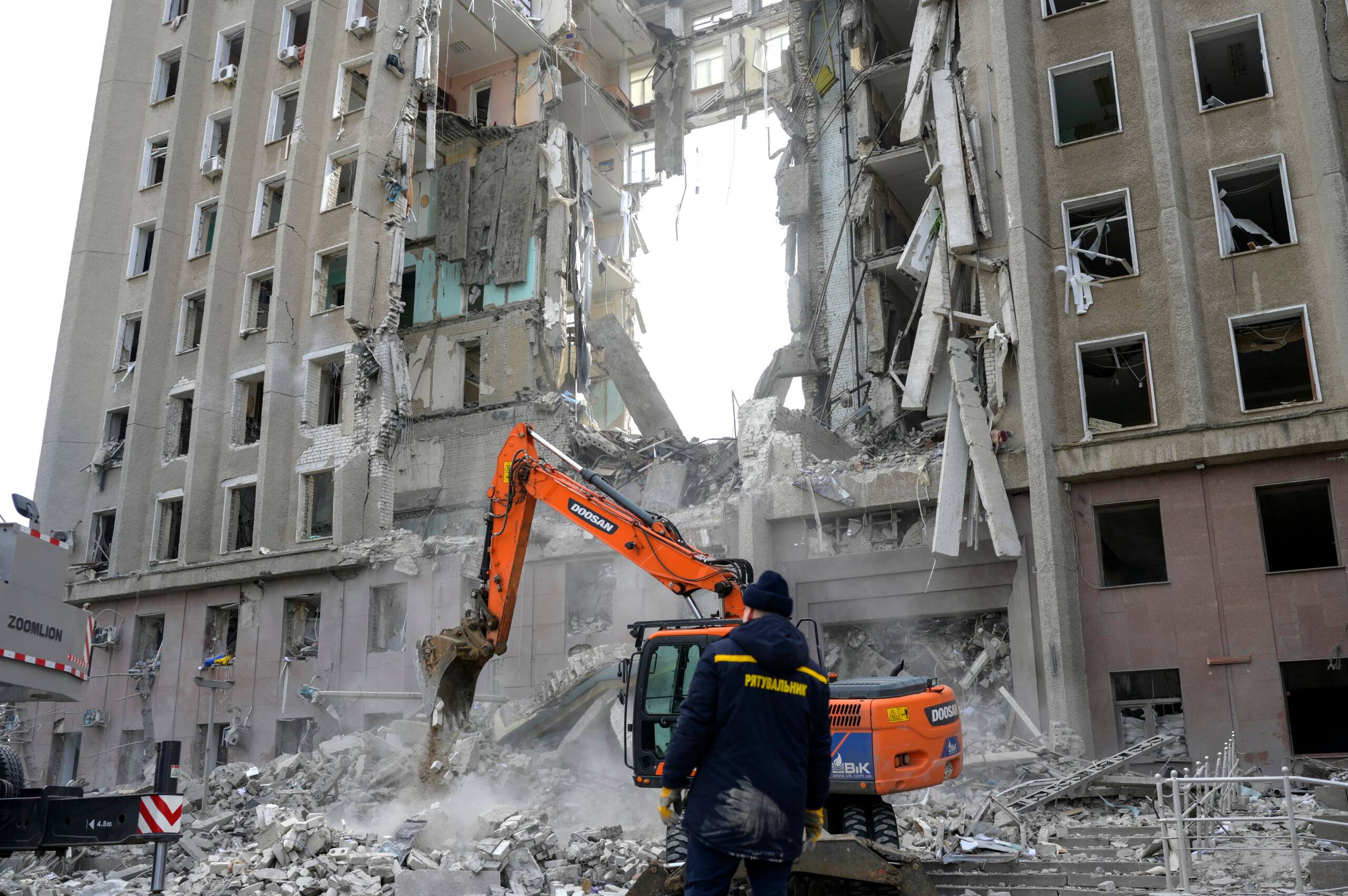 A worker watches an excavator clearing the rubble of a government building hit by Russian rockets in Mykolaiv on March 29, 2022. - A Russian strike battered the regional government building in the southern Ukrainian city of Mykolaiv, a key port under heavy assault for weeks, the regional governor said on March 29, 2022. Governor Vitaly Kim said that most people inside the building had not been injured but several civilians and soldiers were unaccounted for. (