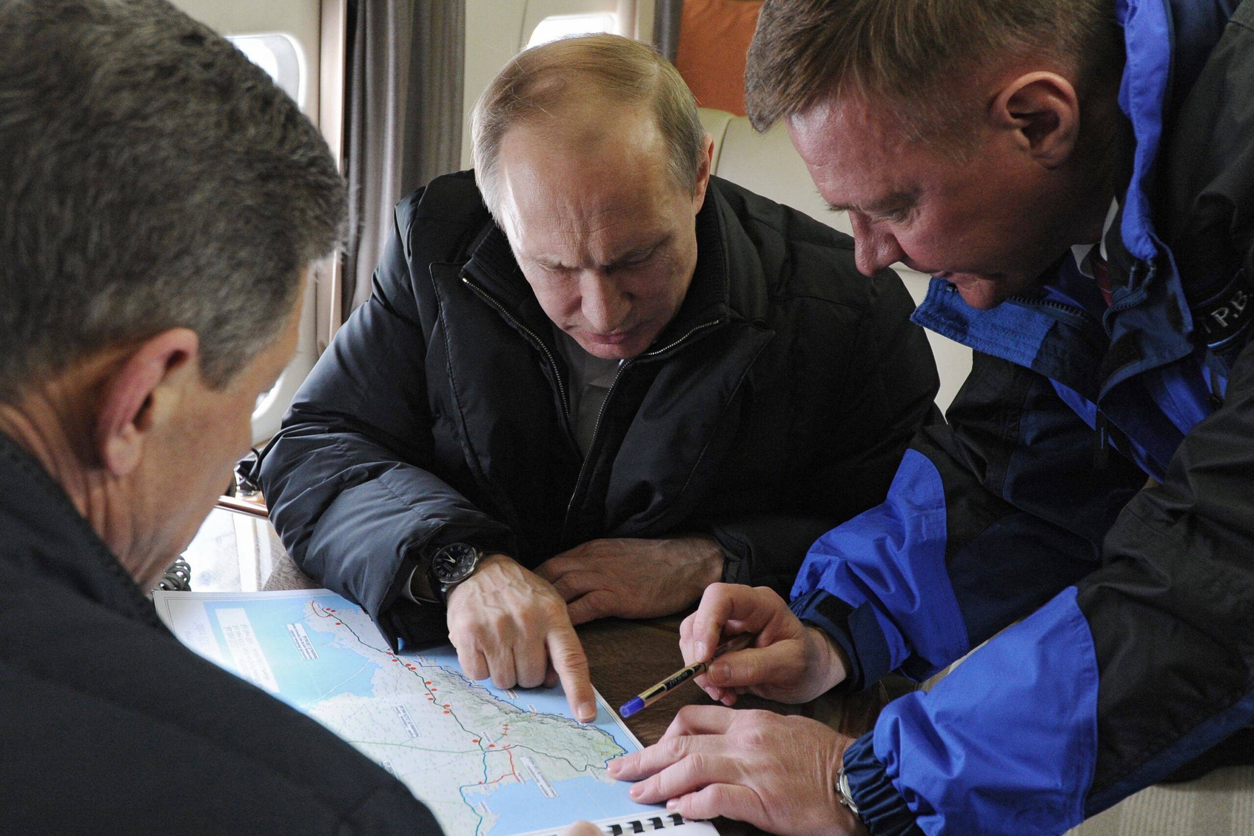Putin pochyla się nad mapa Krymu
