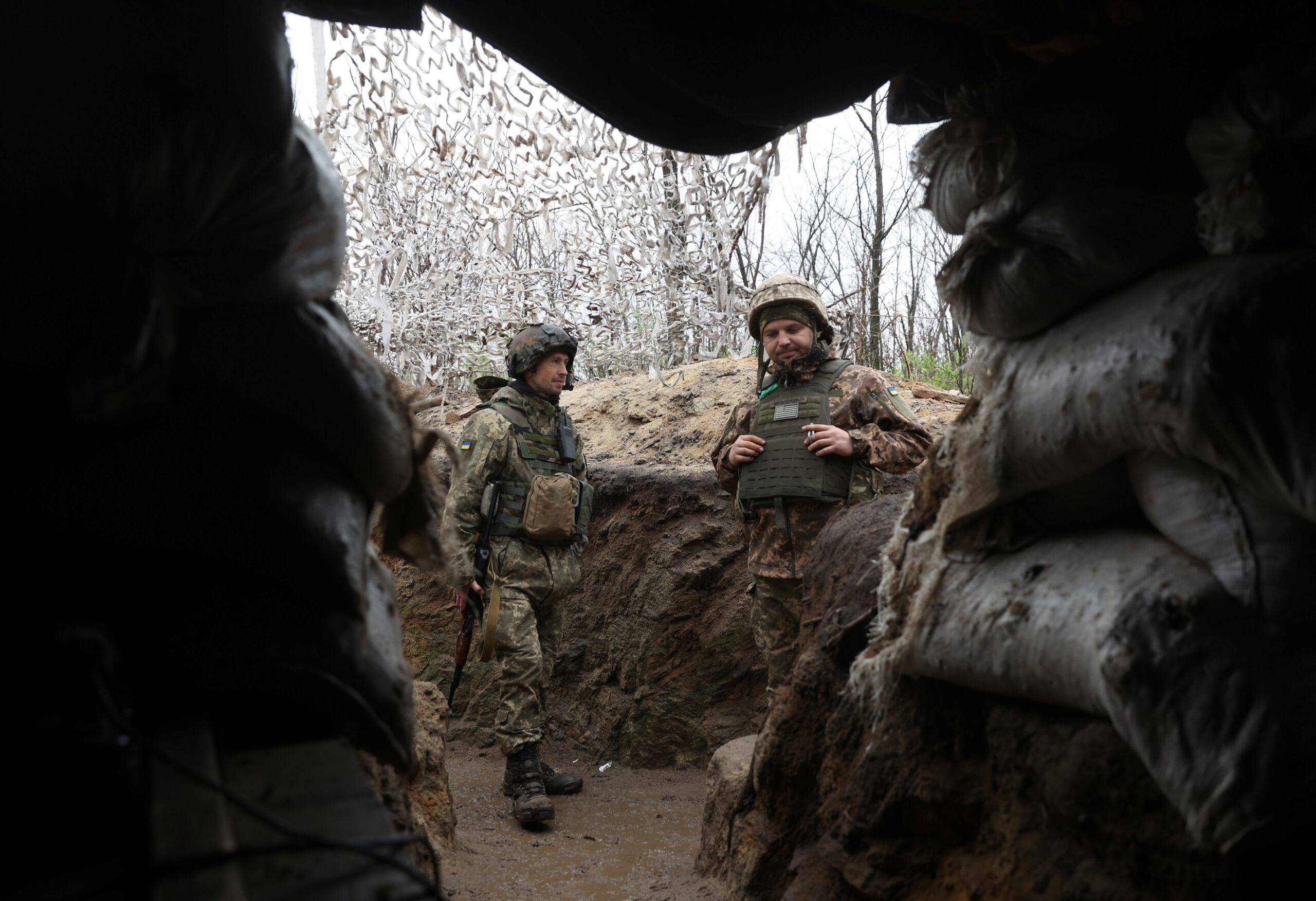dwaj żołnierze stoją w okopach u wlotu do bunkra