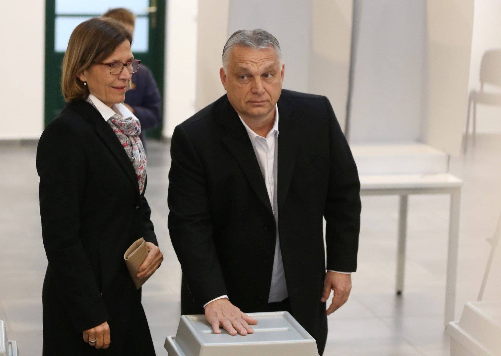 Viktor Orbán z żoną nacylony nad urną wyborczą, na której trzyma rękę