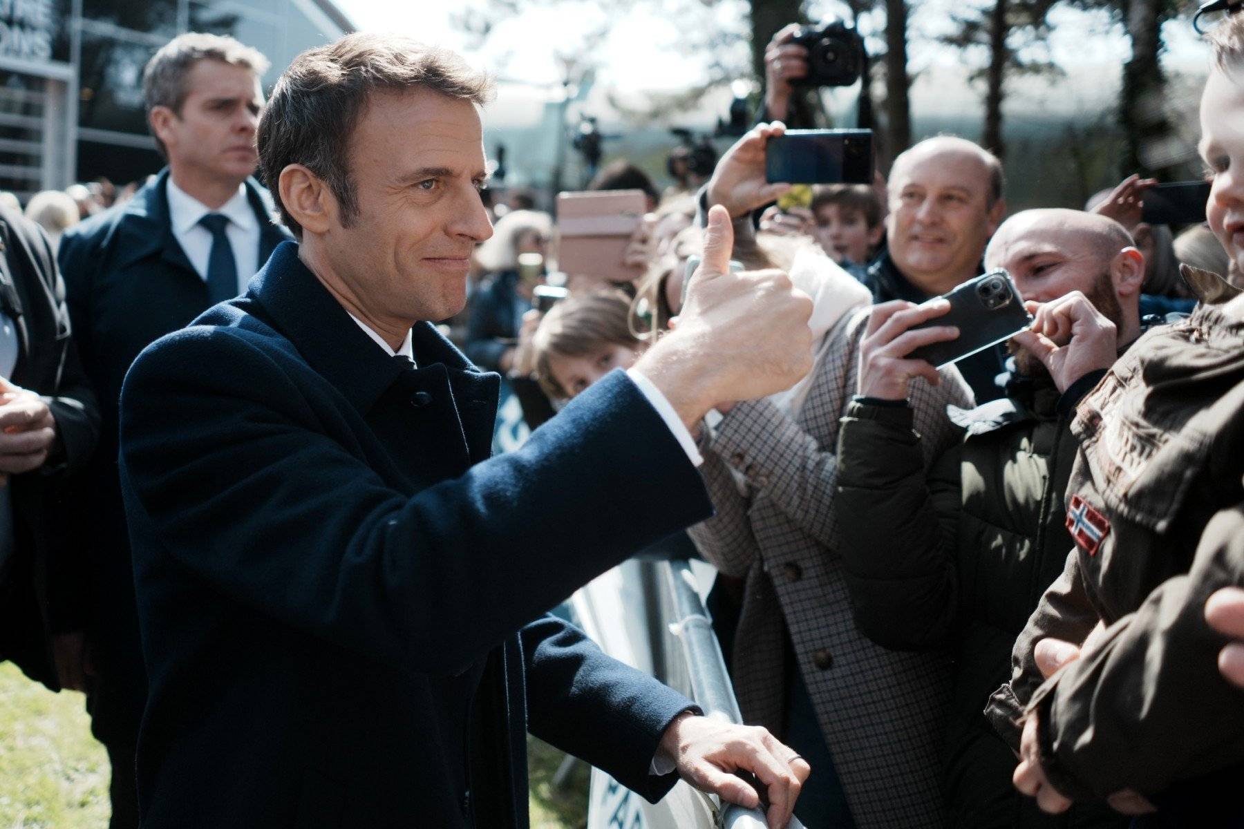 Macron uśmiechnięty podnosi kciuk do góry