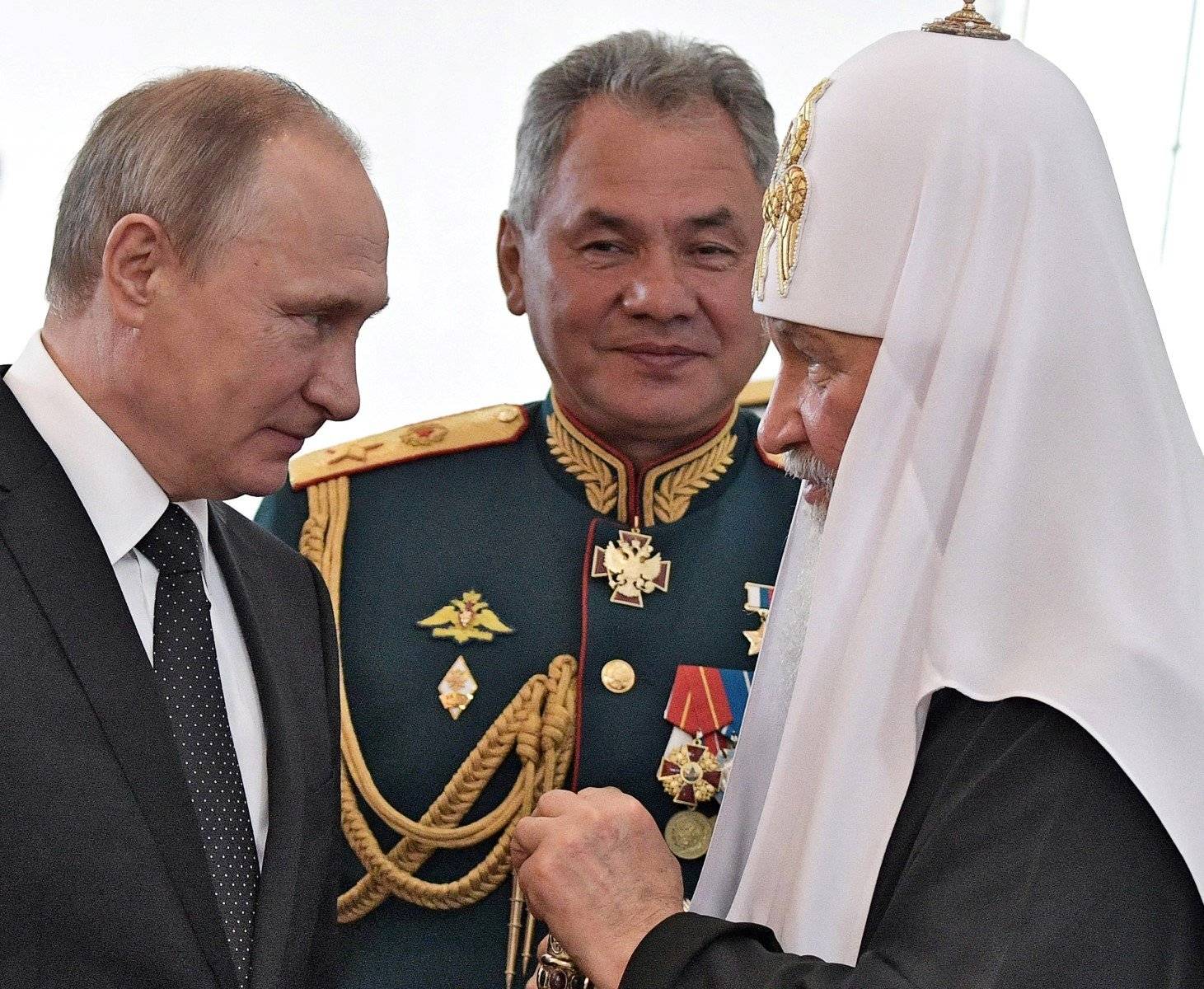 Putin z lewej, patriarcha Cyryl z prawej, w tle Szpjgu w mundurze generalskim