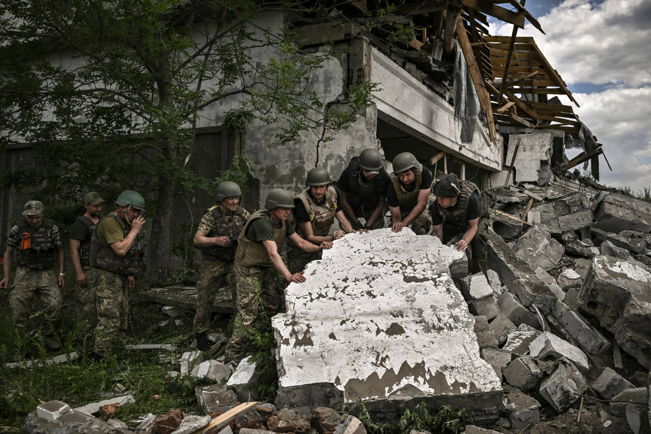 Ukraińscy żołnierze przed zniszczonym budynkiem w Łysyczańsku