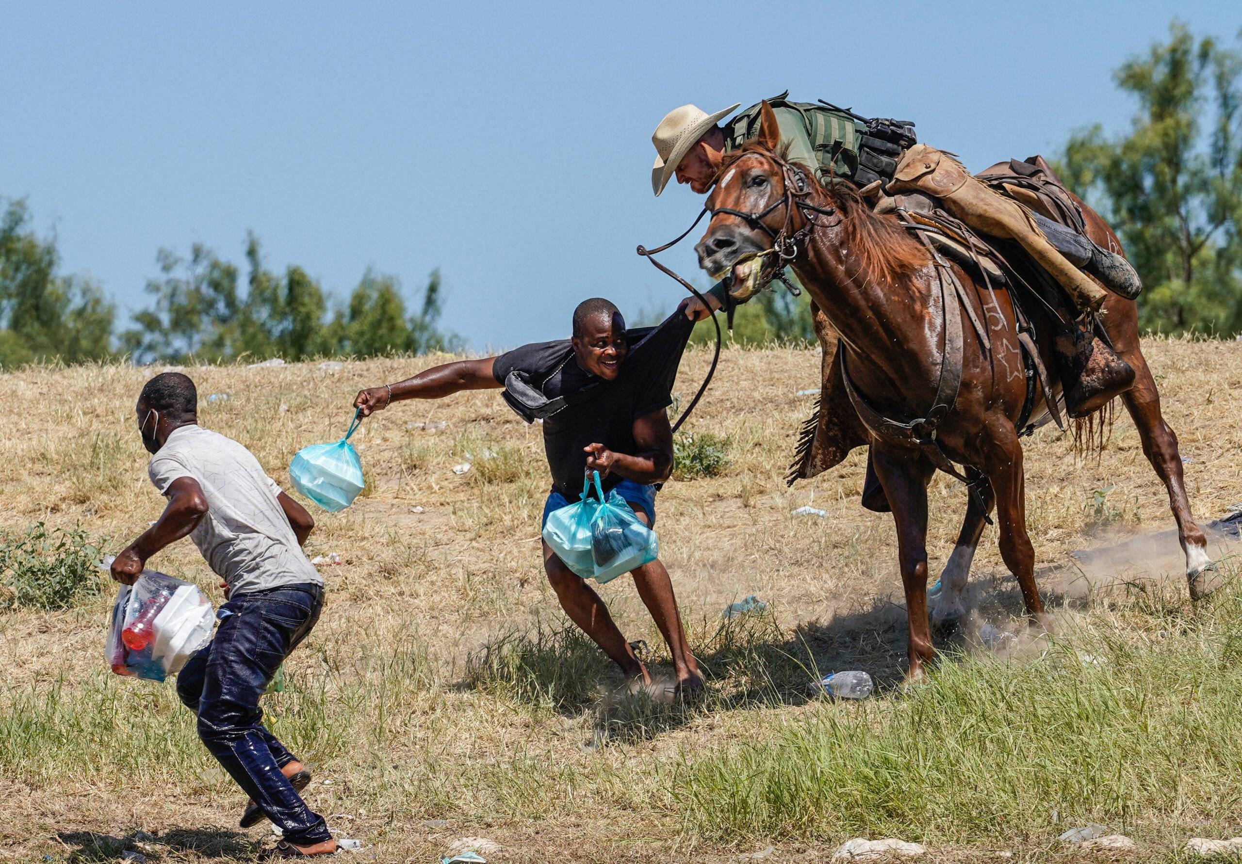 A United States Border Patrol agent on horseback tries to stop a Haitian migrant from entering an encampment on the banks of the Rio Grande near the Acuna Del Rio International Bridge in Del Rio, Texas on September 19, 2021. - The United States said Saturday it would ramp up deportation flights for thousands of migrants who flooded into the Texas border city of Del Rio, as authorities scramble to alleviate a burgeoning crisis for President Joe Biden's administration. (Photo by PAUL RATJE / AFP)