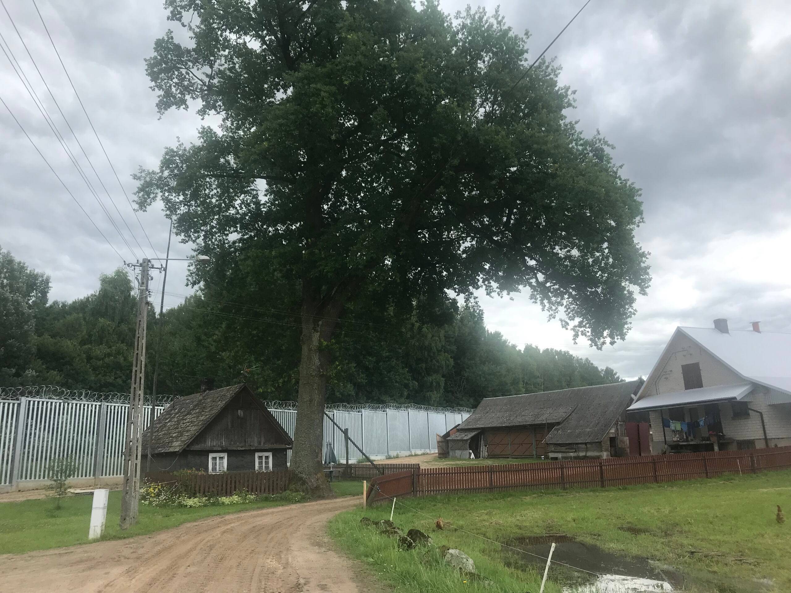 wiejskie domy obok płotu granicznego