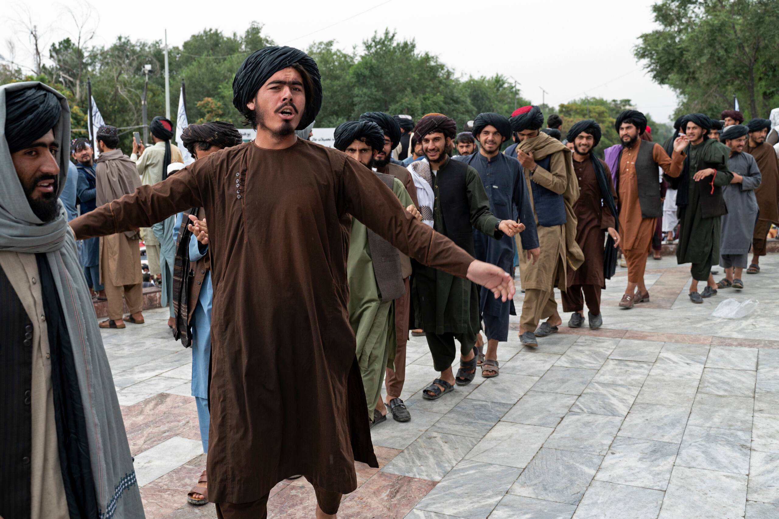 Taliban fighters dance as they celebrate their victory at the Ahmad Shah Massoud Square in Kabul on August 15, 2022. - Taliban fighters chanted victory slogans next to the US embassy in Kabul on August 15 as they marked the first anniversary of their return to power in Afghanistan following a turbulent year that saw women's rights crushed and a humanitarian crisis worsen. (Photo by Wakil KOHSAR / AFP)