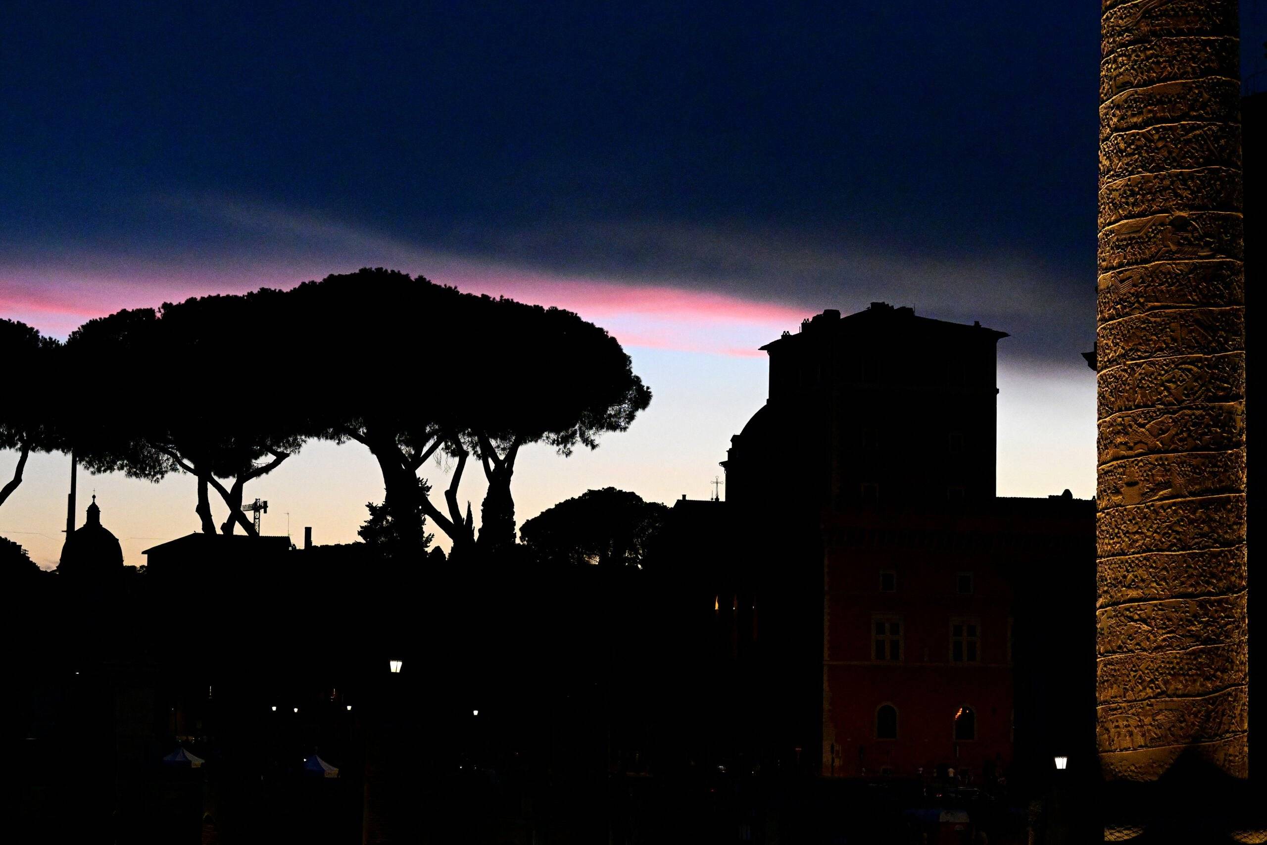 The sun sets over the Trajan forum in central Rome on August 21, 2022. (Photo by Vincenzo PINTO / AFP)