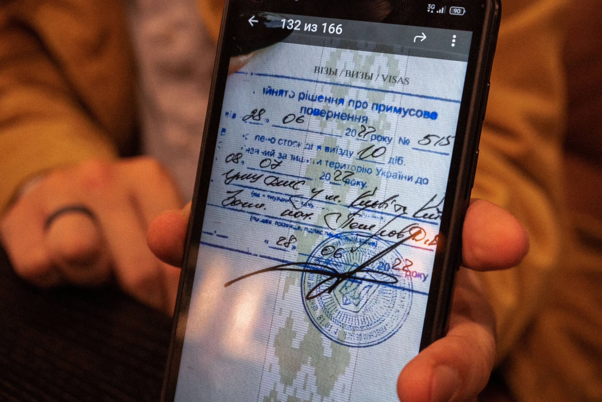 zdjęcie w telefonie pokazujące stronę paszportu z urzędową pieczątka