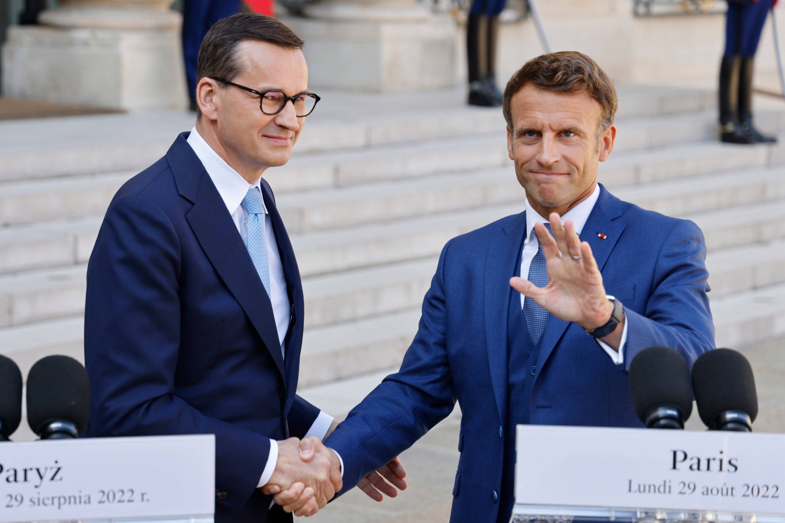 French President Emmanuel Macron (R) and Polish Prime Minister Mateusz Morawiecki shake hands during a press statement  prior to their meeting at the Elysee Palace in Paris on August 29, 2022. (Photo by Ludovic MARIN / AFP)