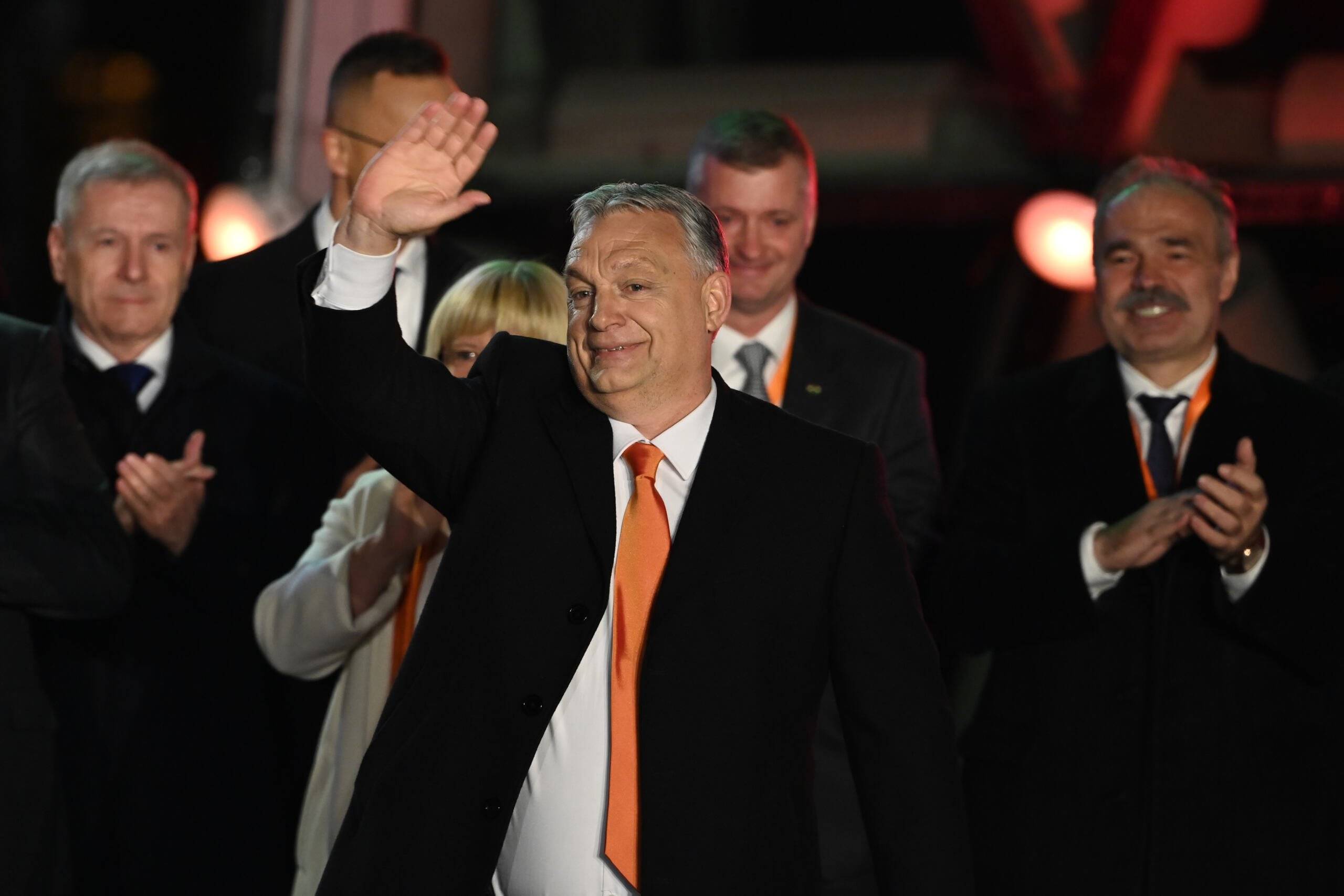 Hungarian Prime Minister Viktor Orban and members of the Fidesz party celebrate on stage at their election base, 'Balna' building on the bank of the Danube River of Budapest, on April 3, 2022. - Nationalist Hungarian Prime Minister Viktor Orban claimed a "great victory" in general election, as partial results gave his Fidesz party the lead. (Photo by Attila KISBENEDEK / AFP)