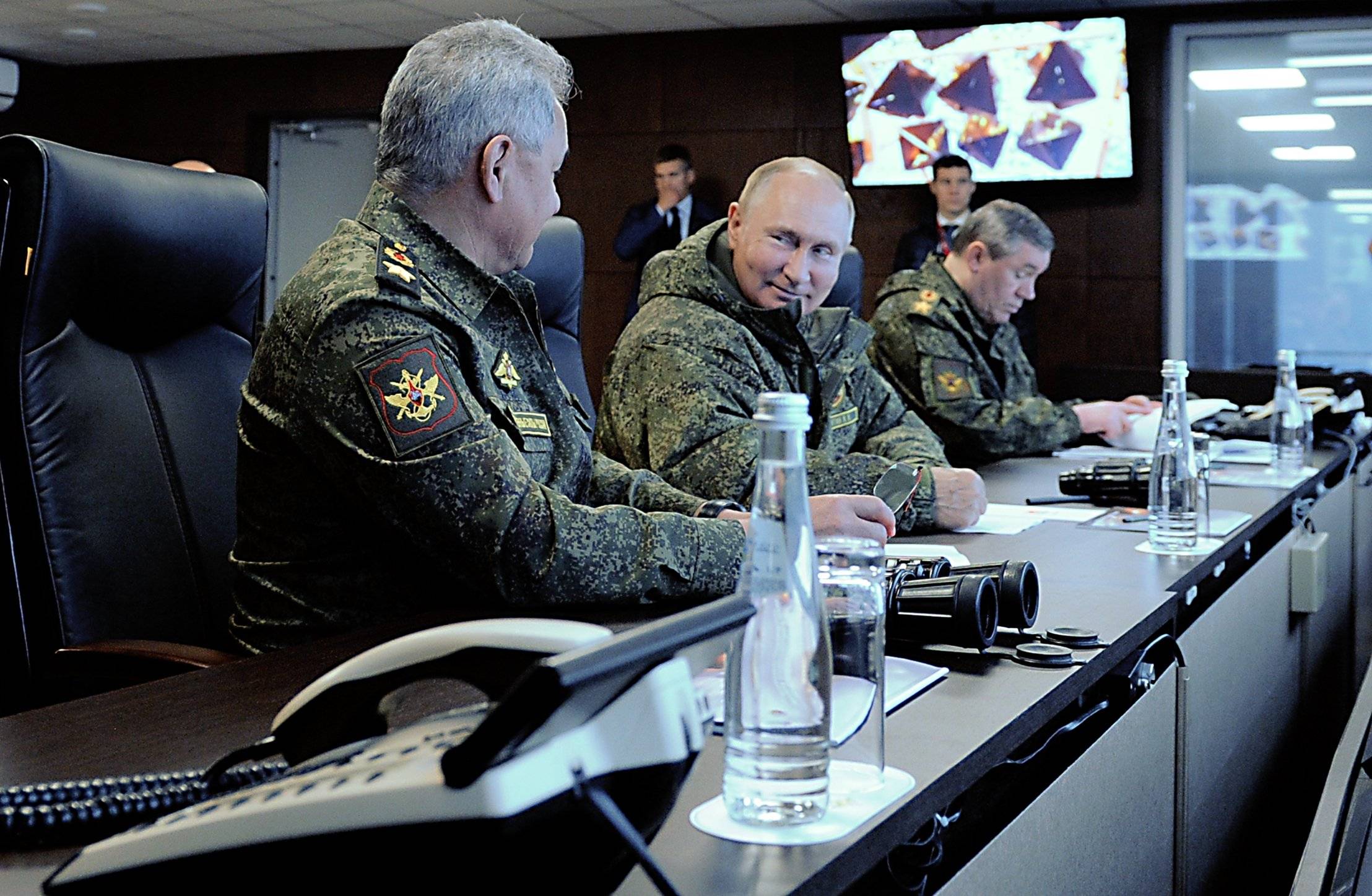 Dwaj mężczyźni ubrani w mundury siedzą przy długim stole konferencyjnym