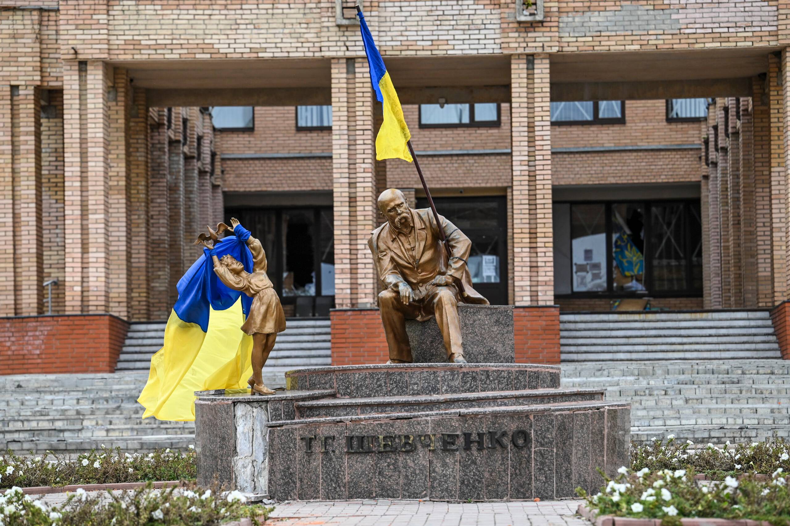A photograph taken on September 10 , 2022, shows Ukrainian flags placed on statues in a square in Balakliya, Kharkiv region, amid the Russian invasion of Ukraine. - Ukrainian forces said on September 10, 2022 they had entered the town of Kupiansk in eastern Ukraine, dislodging Russian troops from a key logistics hub in a lightning counter-offensive that has seen swathes of territory recaptured. (Photo by Juan BARRETO / AFP)