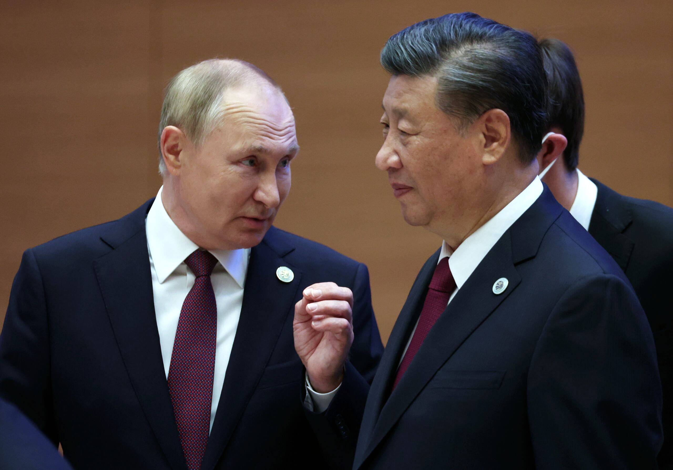 Russian President Vladimir Putin speaks to China's President Xi Jinping during the Shanghai Cooperation Organisation (SCO) leaders' summit in Samarkand on September 16, 2022. (Photo by Sergei BOBYLYOV / SPUTNIK / AFP)