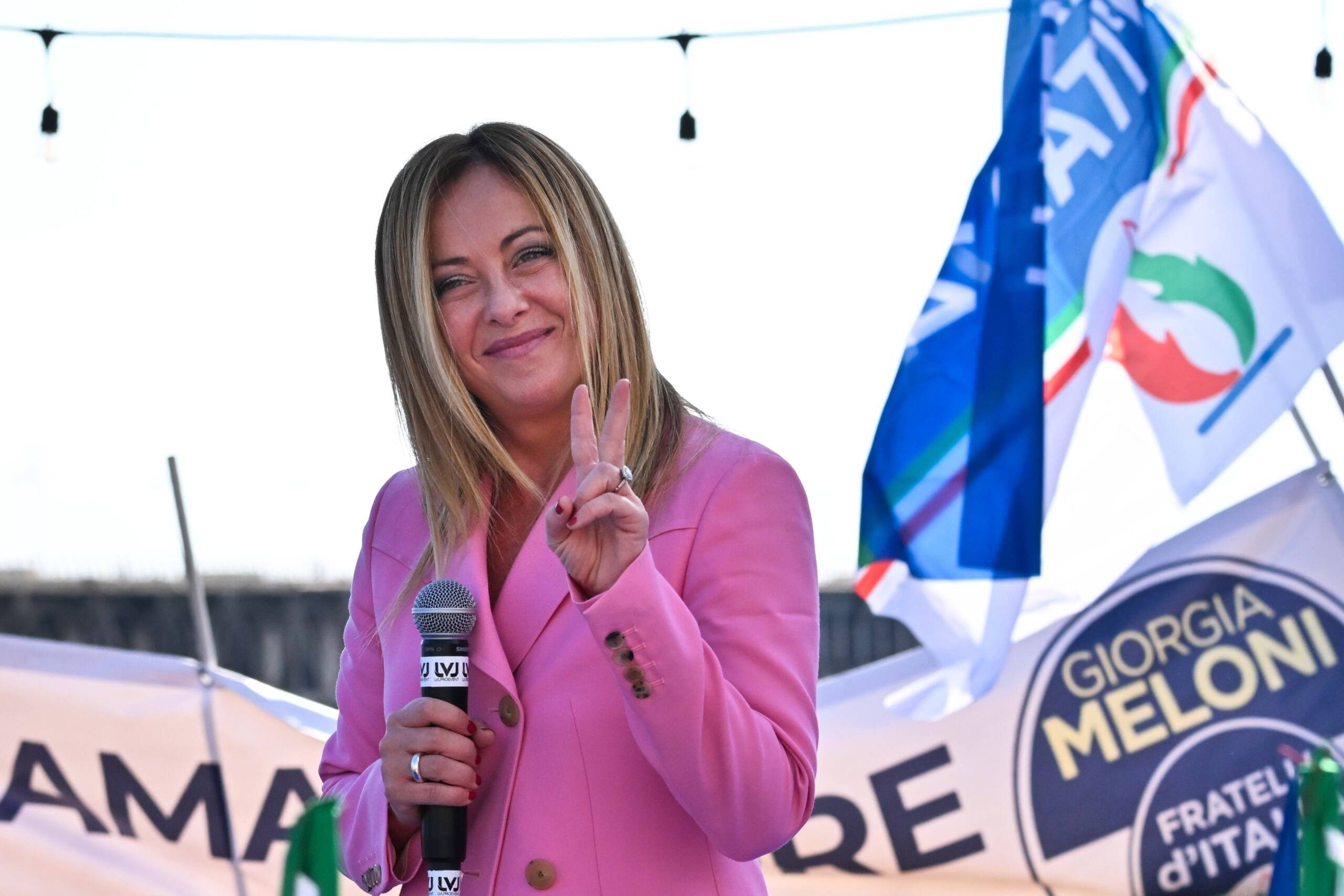Leader of Italian far-right party "Fratelli d'Italia" (Brothers of Italy), Giorgia Meloni flashes the victory sign as she delivers a speech on September 23, 2022 at the Arenile di Bagnoli beachfront location in Naples, southern Italy, during a rally closing her party's campaign for the September 25 general election. (Photo by Andreas SOLARO / AFP)