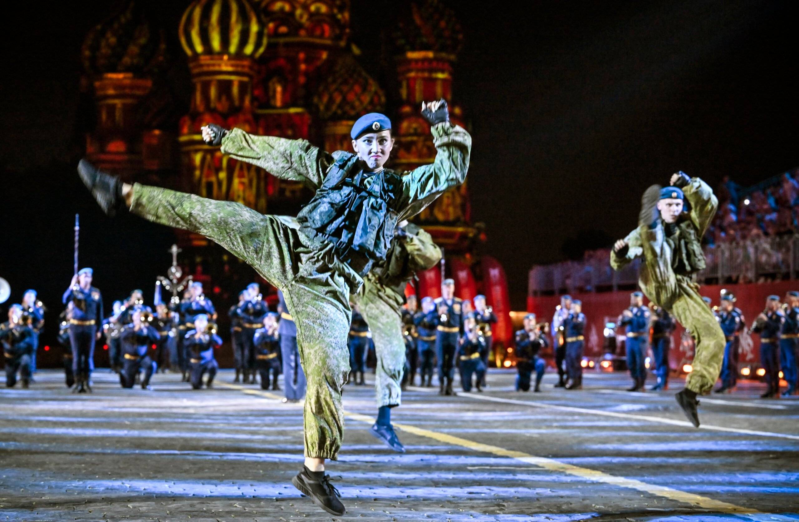 Wieczór, żołnierz w polowym mundurze tańczy na Pl. Czerwonym