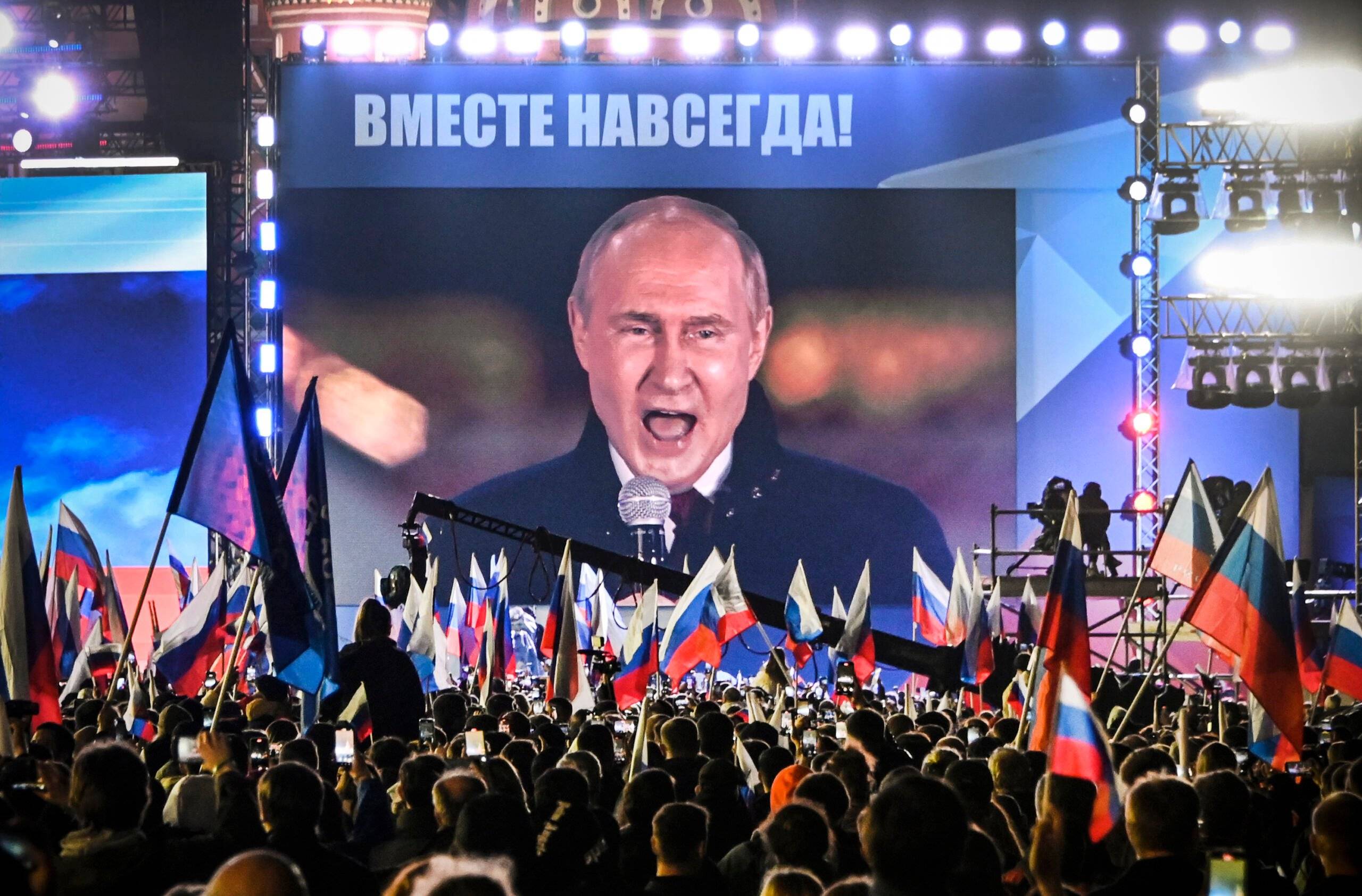 Russian President Vladimir Putin is seen on a screen set at Red Square as he addresses a rally and a concert marking the annexation of four regions of Ukraine Russian troops occupy - Lugansk, Donetsk, Kherson and Zaporizhzhia, in central Moscow on September 30, 2022. (Photo by Alexander NEMENOV / AFP)