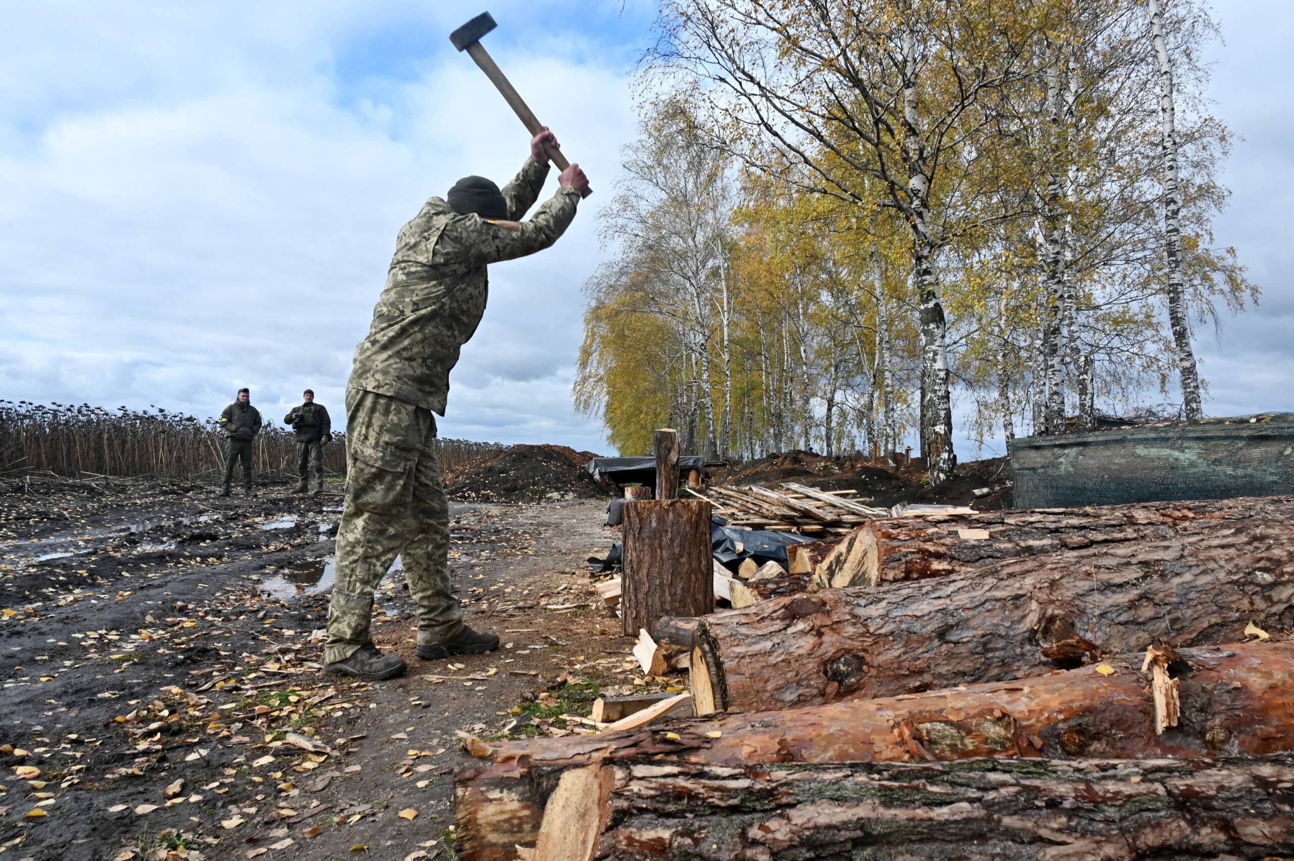 A soldier of the National Guard of Ukraine chops firewood in the northern occupied territories of Kharkiv region on October 21, 2022, amid the Russian military invasion of Ukraine. (Photo by SERGEY BOBOK / AFP)