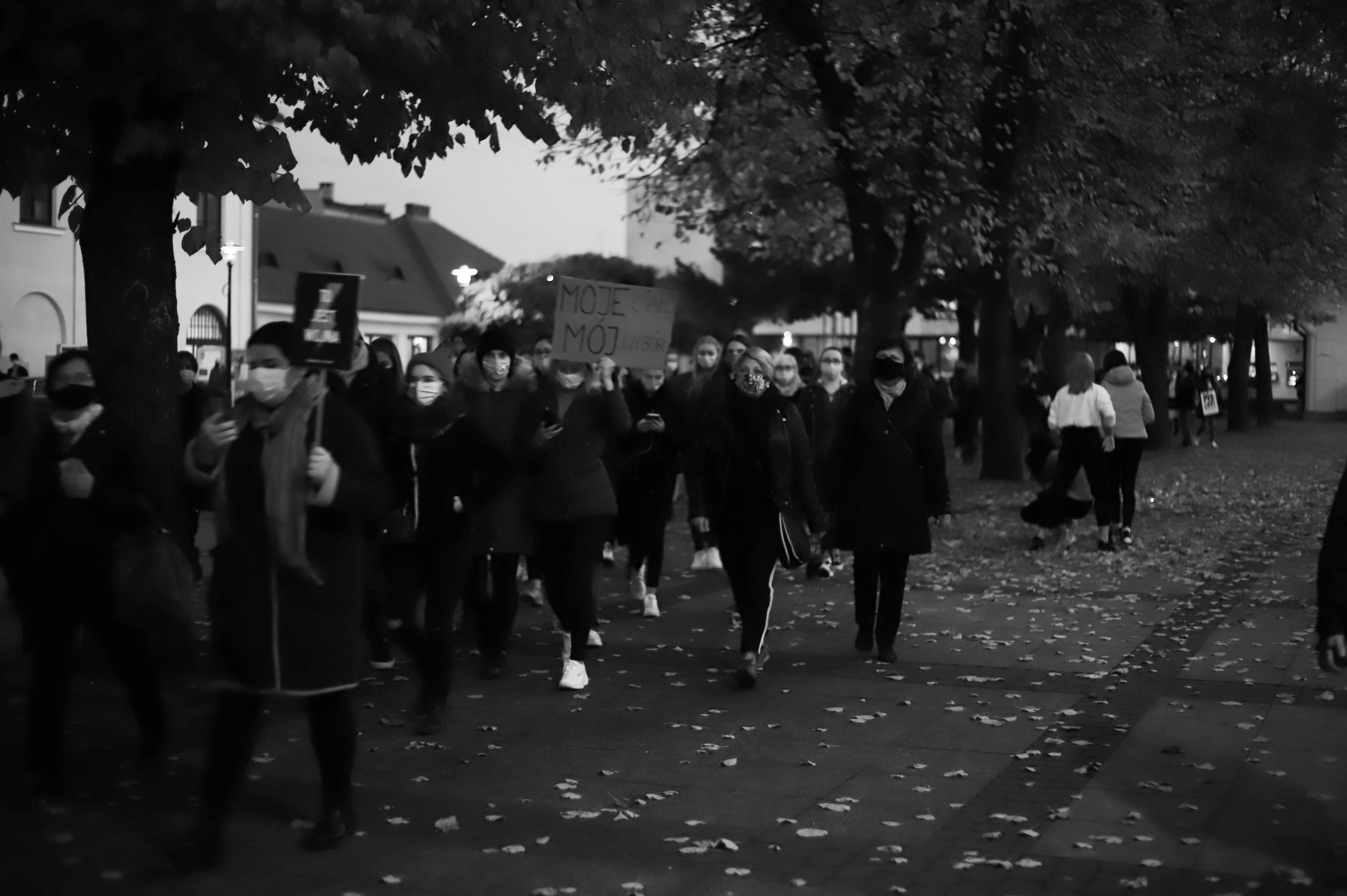 czarno-białe zdjęcie idących o zmroku kobiet