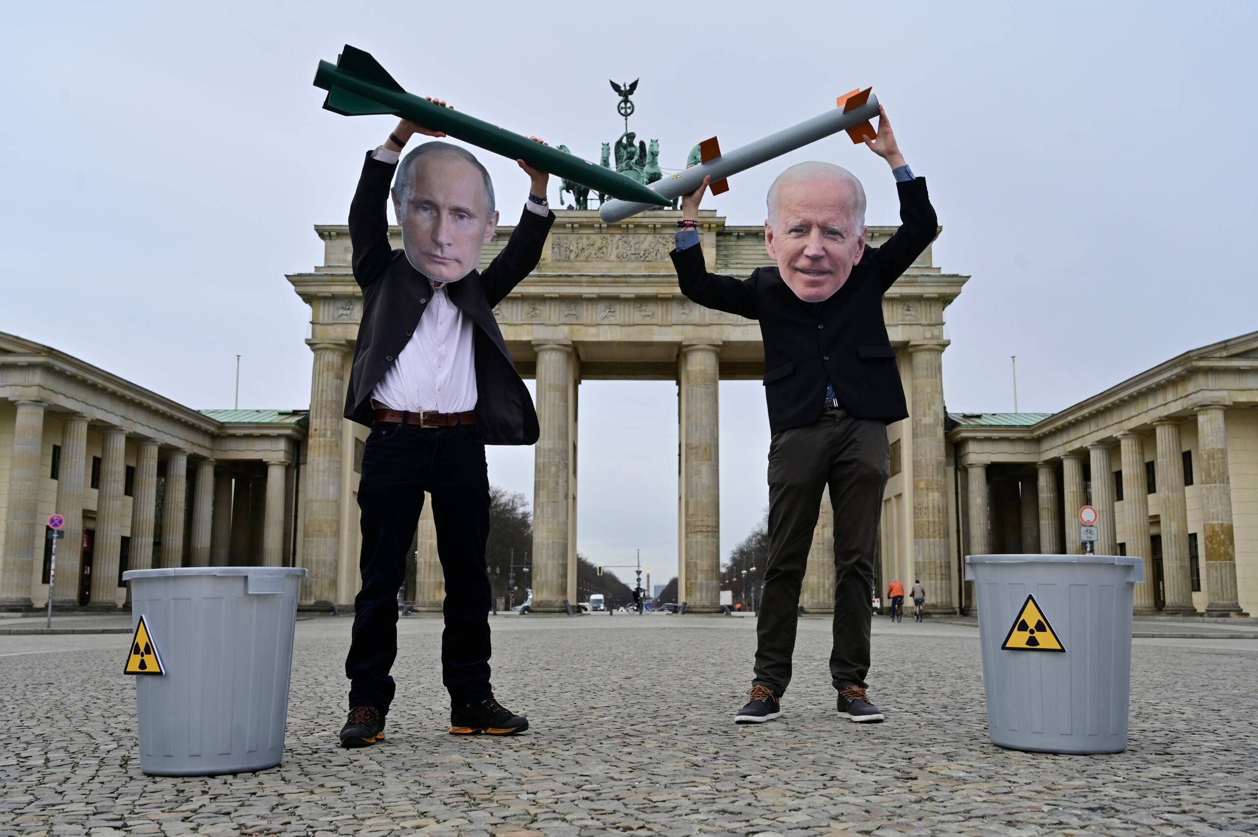 Peace activists wearing masks of Russian President Vladimir Putin (L) and newly elected US President Joe Biden pose with mock nuclear missiles in front of Berlin's landmark the Brandenburg Gate on January 29, 2021 in an action to call for more progress in nuclear disarmament. - The Russian parliament on January 27, 2021 unanimously voted to ratify an agreement to extend by five years a key nuclear pact with the United States that was set to expire soon. Signed in 2010, the New START contract caps to 1,550 the number of nuclear warheads that can be deployed by Moscow and Washington, which control the world's largest nuclear arsenals. The agreement, which was due to expire on February 5, is seen as a rare opportunity for compromise between Moscow and Washington, whose ties have dramatically deteriorated in recent years. (Photo by John MACDOUGALL / AFP)