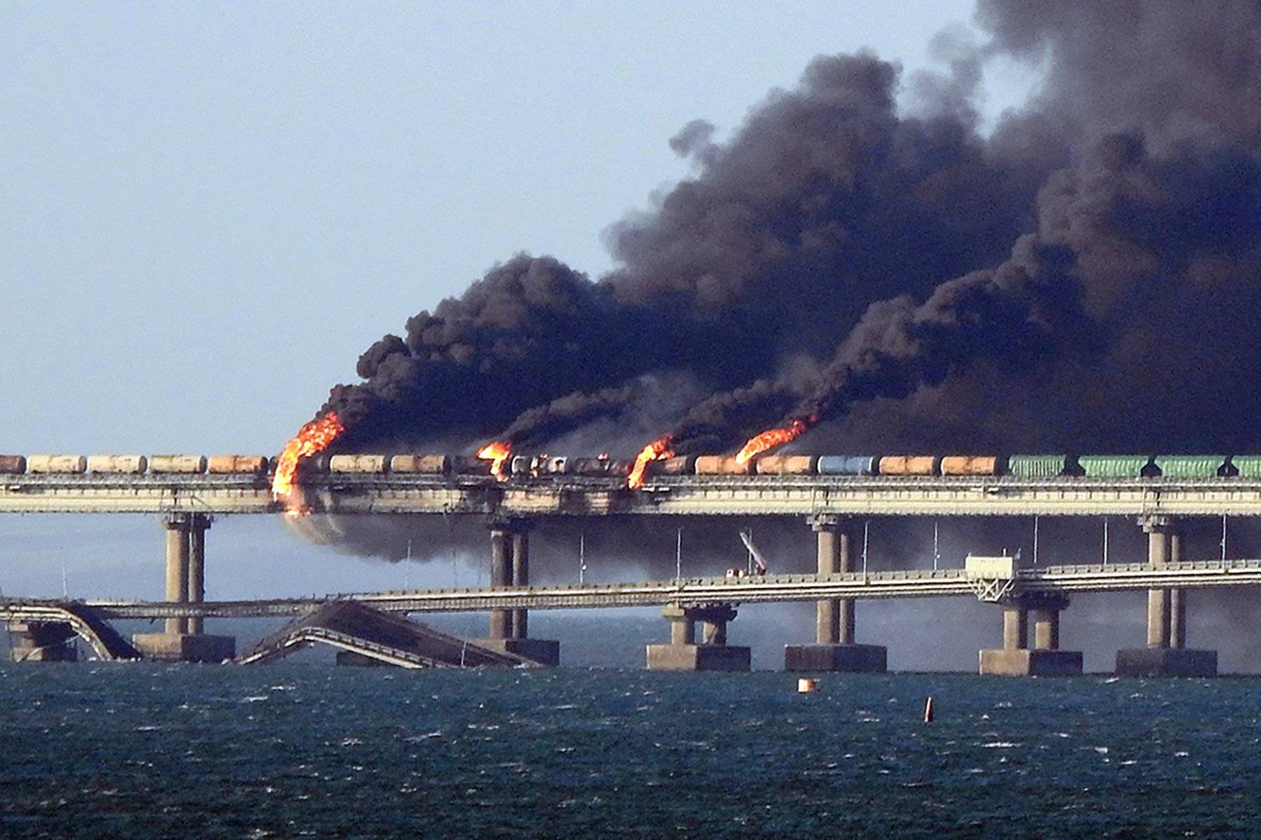 Black smoke billows from a fire on the Kerch bridge that links Crimea to Russia, after a truck exploded, near Kerch, on October 8, 2022. - Moscow announced on October 8, 2022 that a truck exploded igniting a huge fire and damaging the key Kerch bridge -- built as Russia's sole land link with annexed Crimea -- and vowed to find the perpetrators, without immediately blaming Ukraine. (Photo by - / AFP)