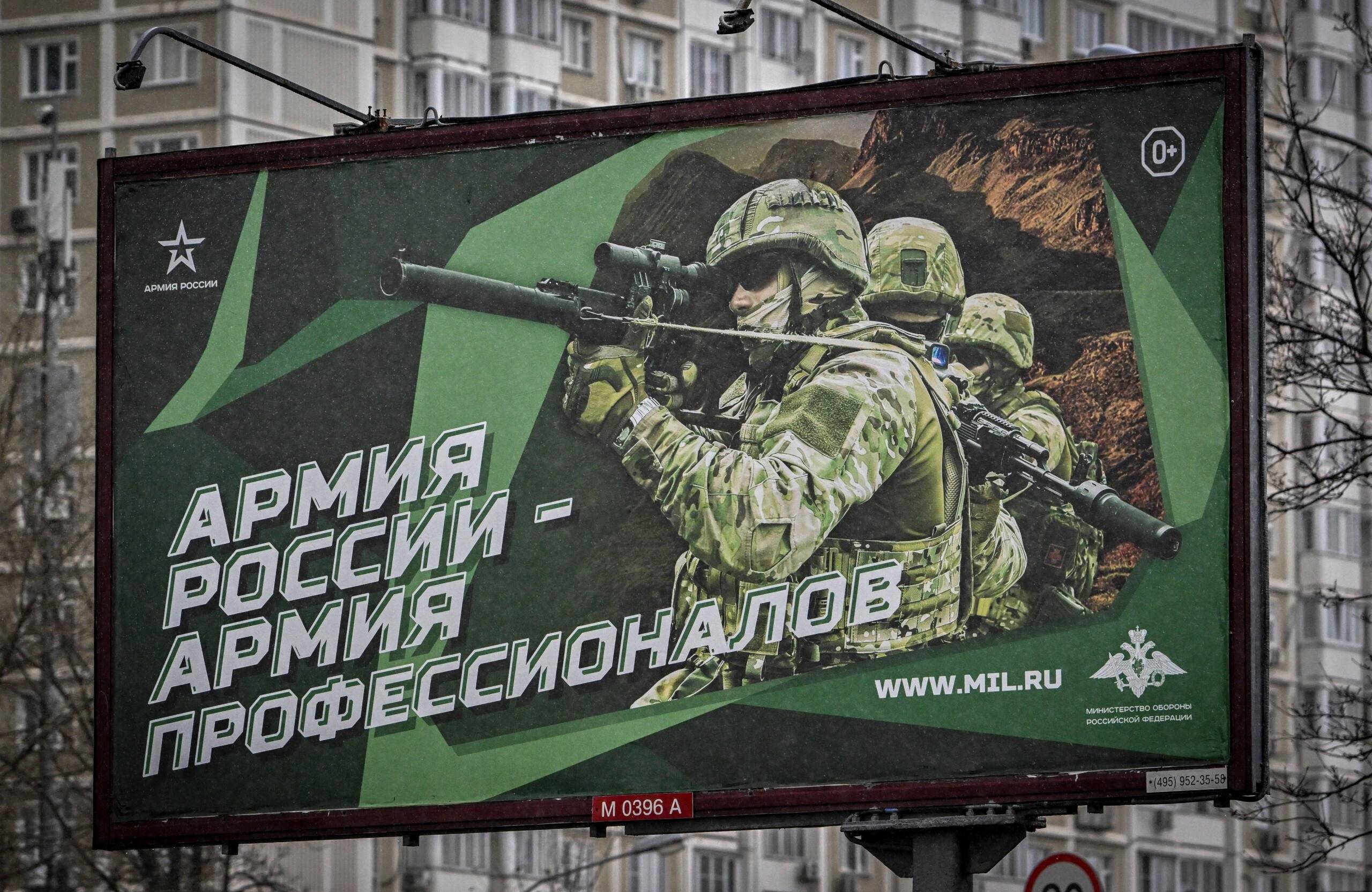 A photograph taken on October 24, 2022 shows a poster displaying Russian soldiers with a slogan reading 'Army of Russia - Army of professionals' decorating a street in Moscow. (Photo by Yuri KADOBNOV / AFP)