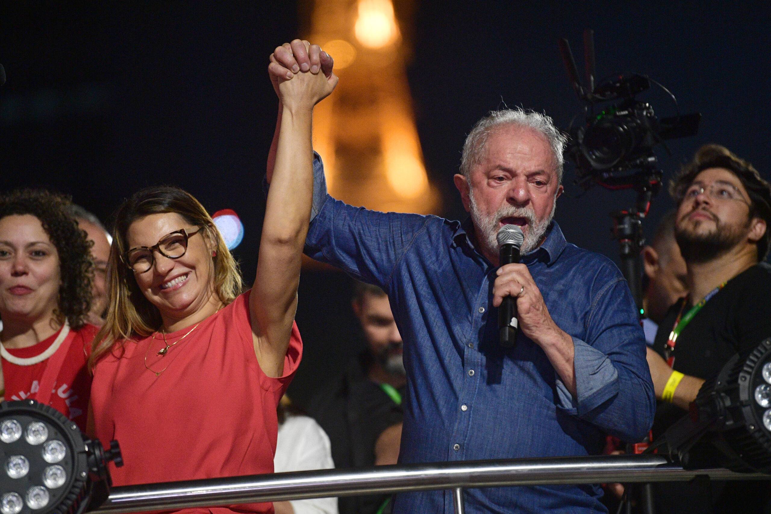 Brazilian president-elect for the leftist Workers Party (PT) Luiz Inacio Lula da Silva holds the hand of his wife, Rosangela "Janja" da Silva, while delivering a speech to supporters at the Paulista avenue after winning the presidential run-off election, in Sao Paulo, Brazil, on October 30, 2022. - Brazil's veteran leftist Luiz Inacio Lula da Silva was elected president Sunday by a hair's breadth, beating his far-right rival in a down-to-the-wire poll that split the country in two, election officials said. (Photo by CARL DE SOUZA / AFP)