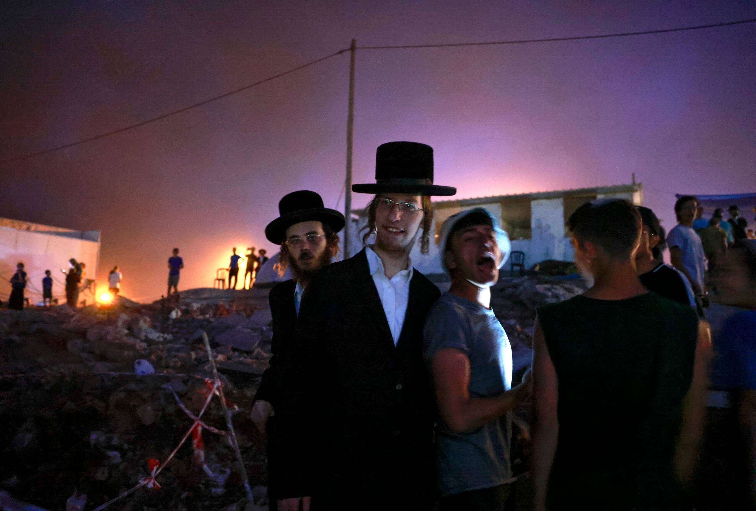 Israeli ultra-Orthodox men and settlers gather in the newly-established wildcat outpost of Eviatar near the northern Palestinian city of Nablus in the occupied West Bank, on June 28, 2021. - Jewish settlers agreed to leave a new outpost in the occupied West Bank that has stirred weeks of Palestinian protests following a deal with Israel's government, in an agreement confirmed by the interior ministry and settler leaders, under which they will leave the Eviatar outpost within days but their mobile homes will remain and Israeli troops will establish a base in the area. (Photo by MENAHEM KAHANA / AFP)