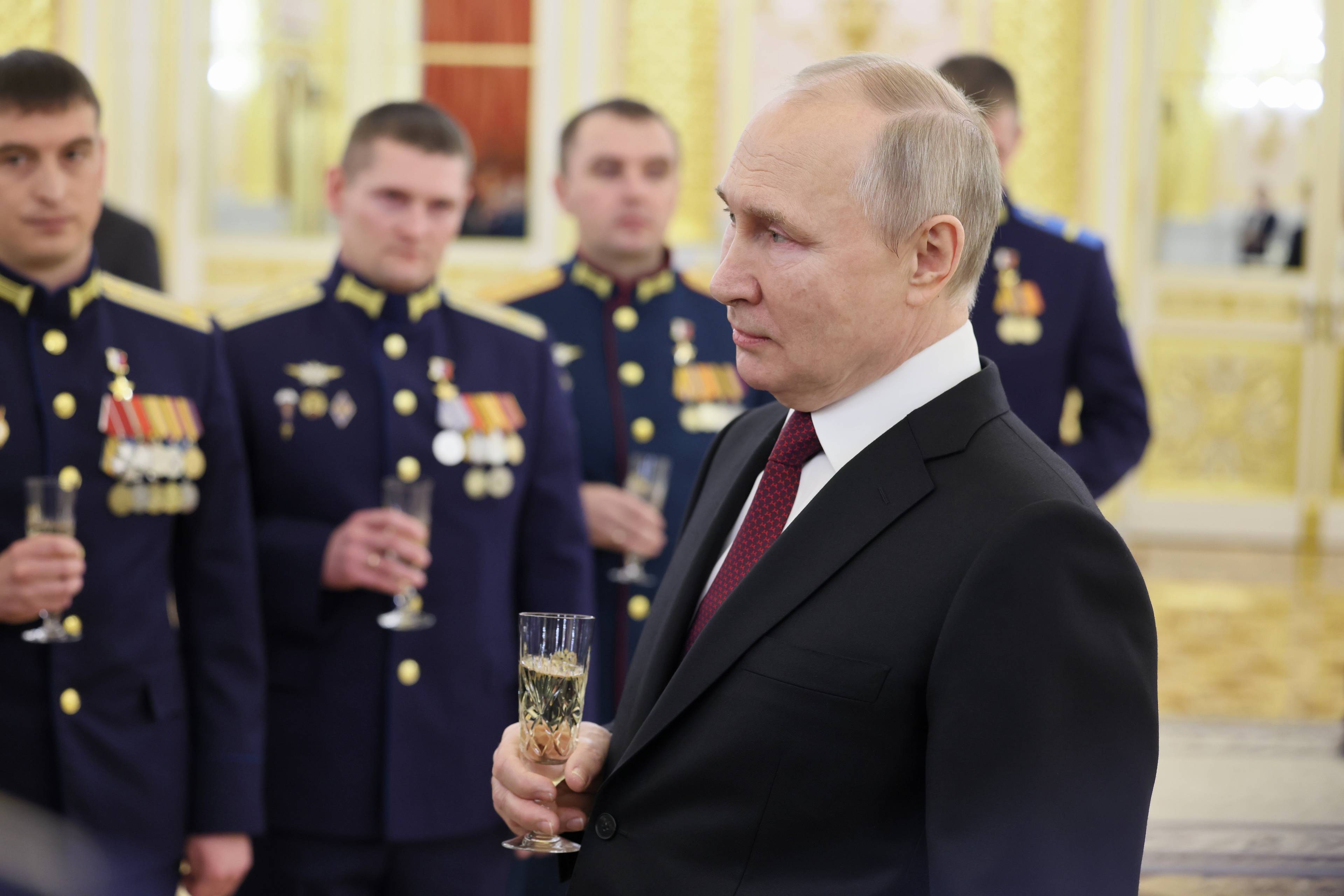 Russian President Vladimir Putin (R) toasts with Russian soldiers after awarding them with the Gold Star medal on the eve of the "Heroes of the Fatherland Day" at the Kremlin in Moscow on December 8, 2022. (Photo by Mikhail Metzel / SPUTNIK / AFP)