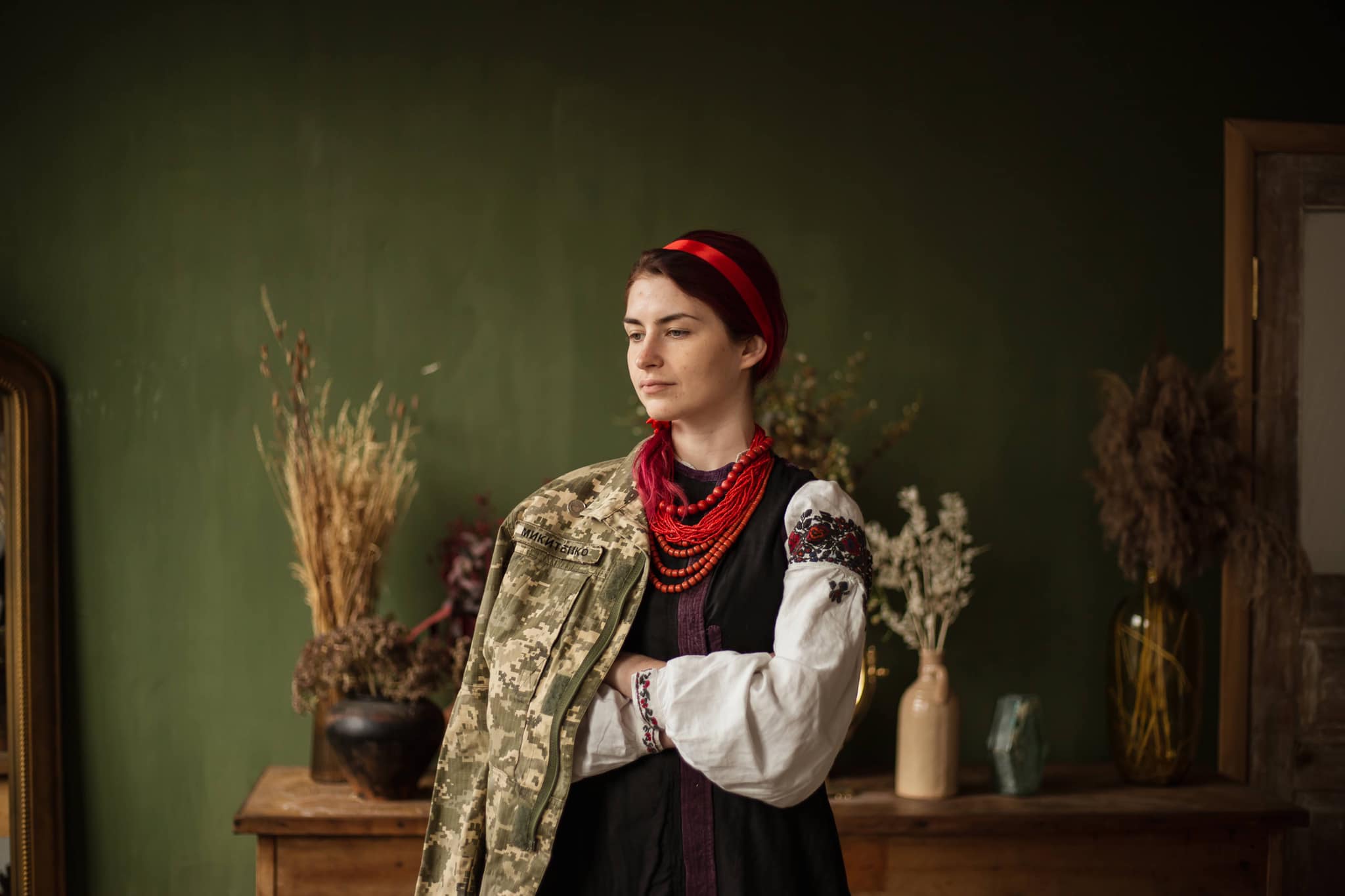 kobieta w ludowym stroju ukraińskim, z przewieszoną przez ramię kurtką mundurową