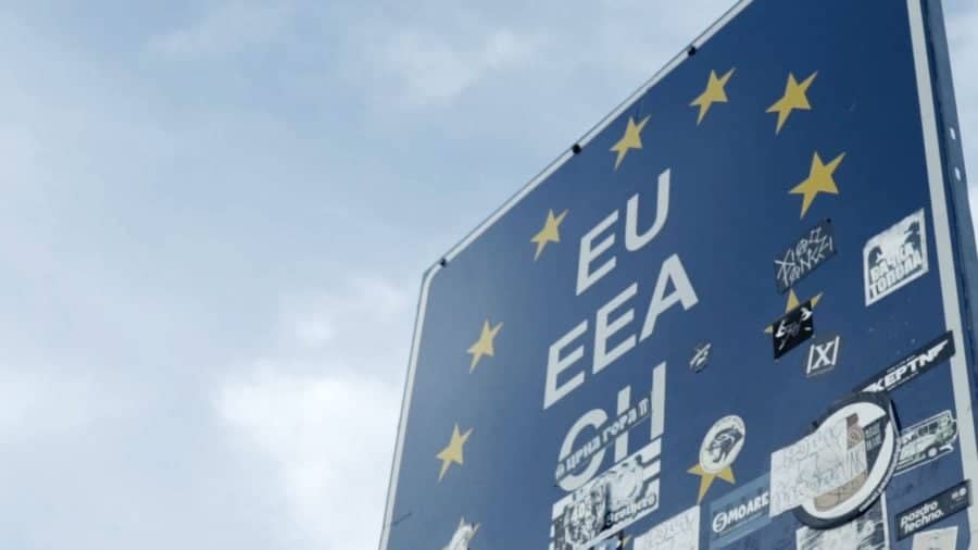 Niebieska tablica graniczna Unii Europejskiej na tle nieba