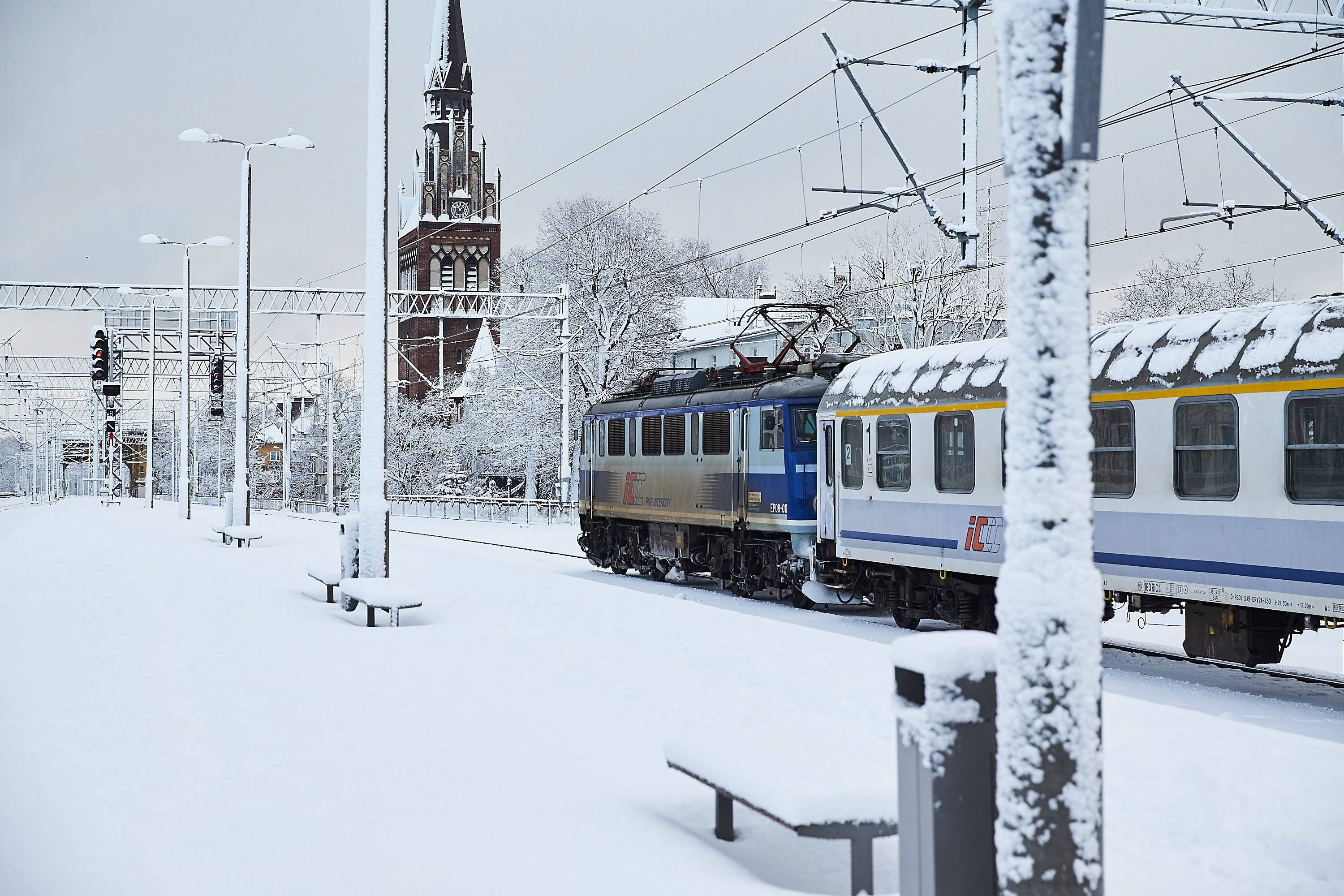 Pociąg w zimowej scenerii wjeżdża na dworzec Gdańsk Wrzeszcz