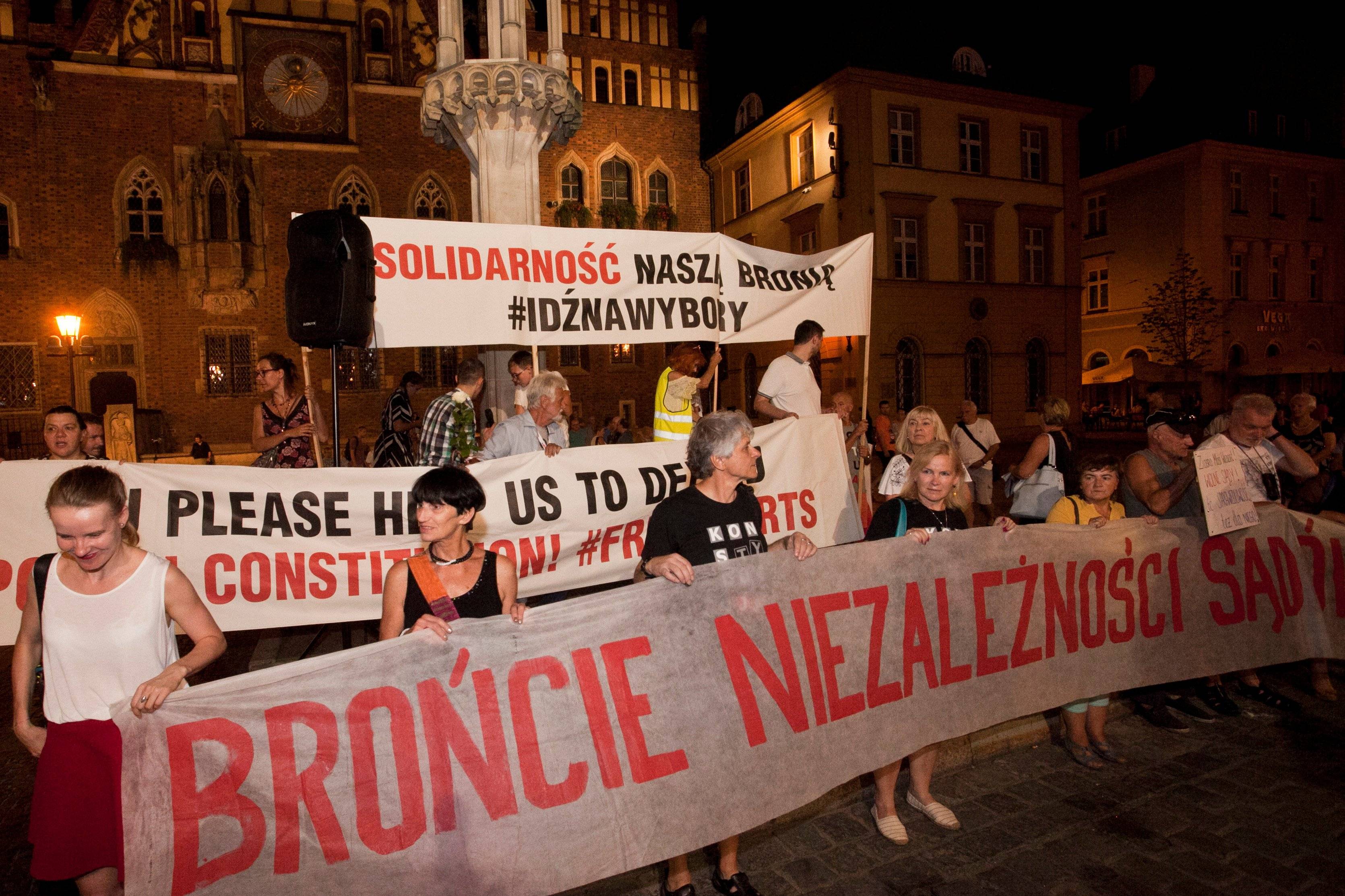na zdjęciu widać osoby stojące na rynku we Wrocławiu z banerami z napisem "brońcie niezależności sądów"