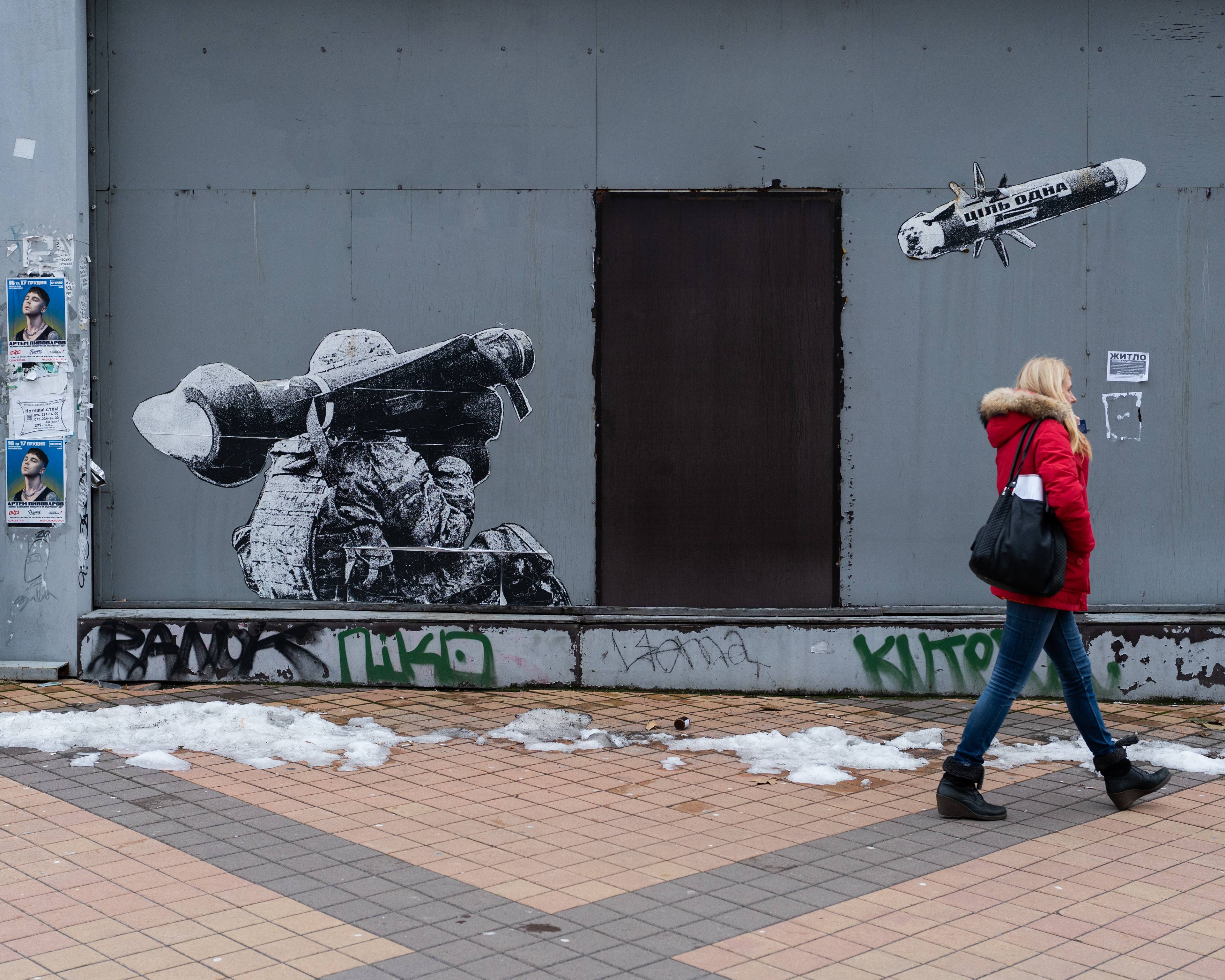 Graffiti uliczne, żołnierz ukraiński z granatnikiem na ramieniu wystrzeliwuje pocisk na napisem jeden cel