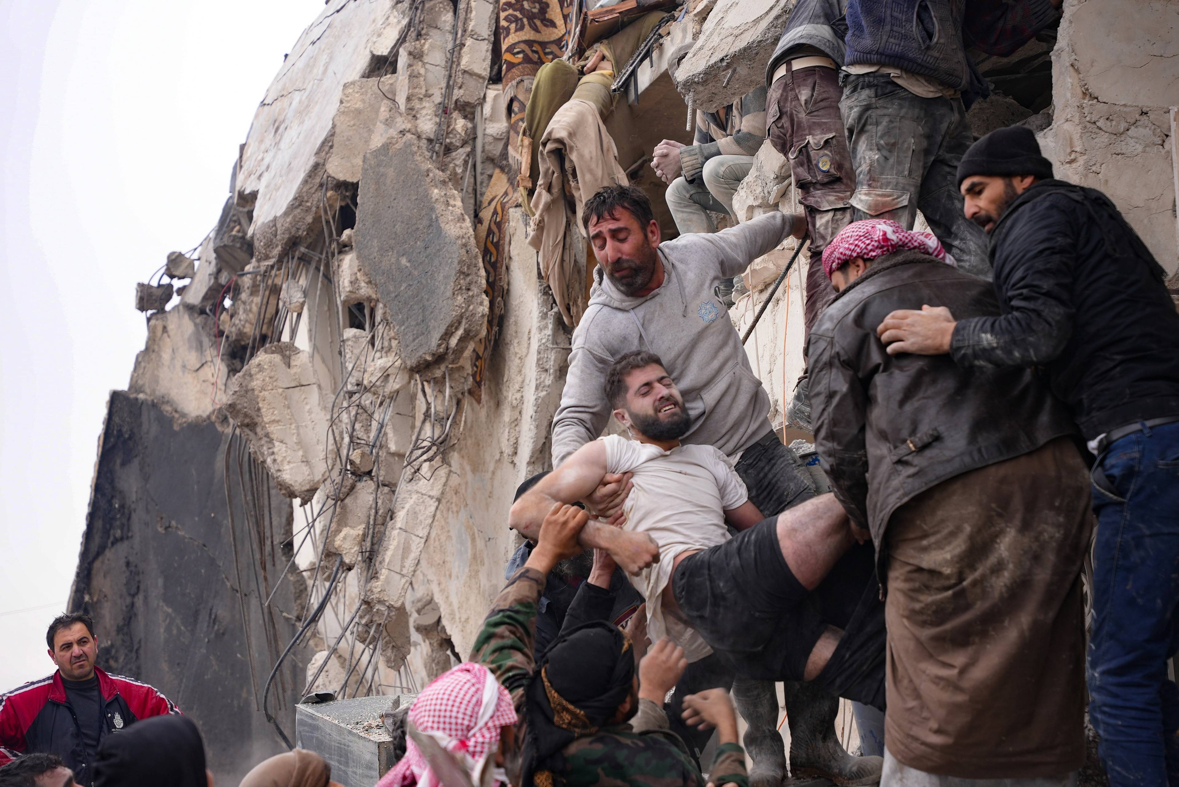 Ofiary trzęsienia ziemi w Syrii i Turcji wynoszone ze ruin zawalonego budynku