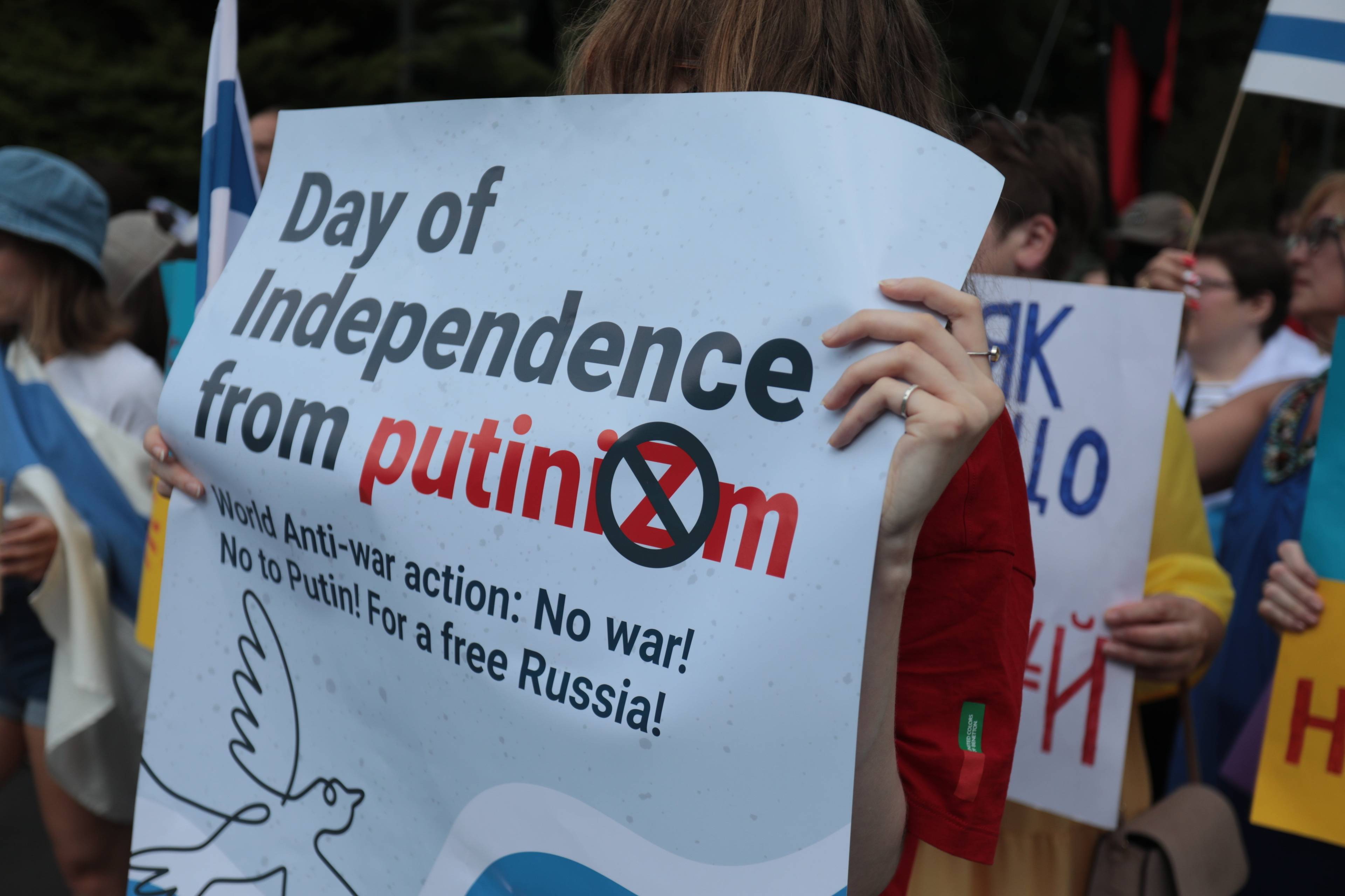 Człowiek trzyma plakat z napisem "Day of inndependence from putinizm" (dzień niepodległości od putinizmu)