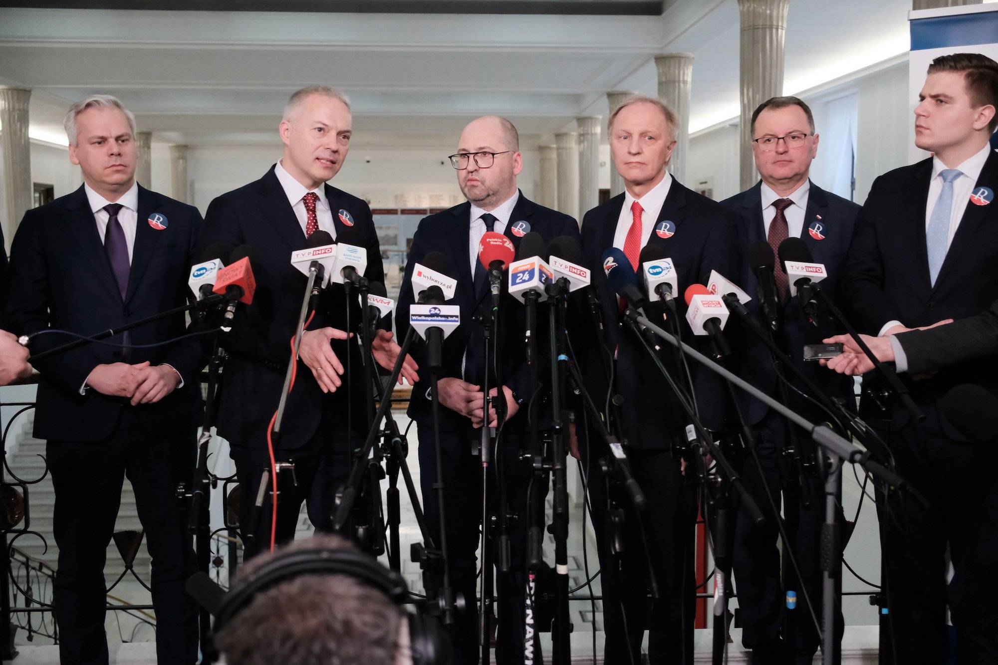 Członkowie Partii Republikańskiej w ciemnych garniturach przemawiają na konferencji prasowej w Sejmie.