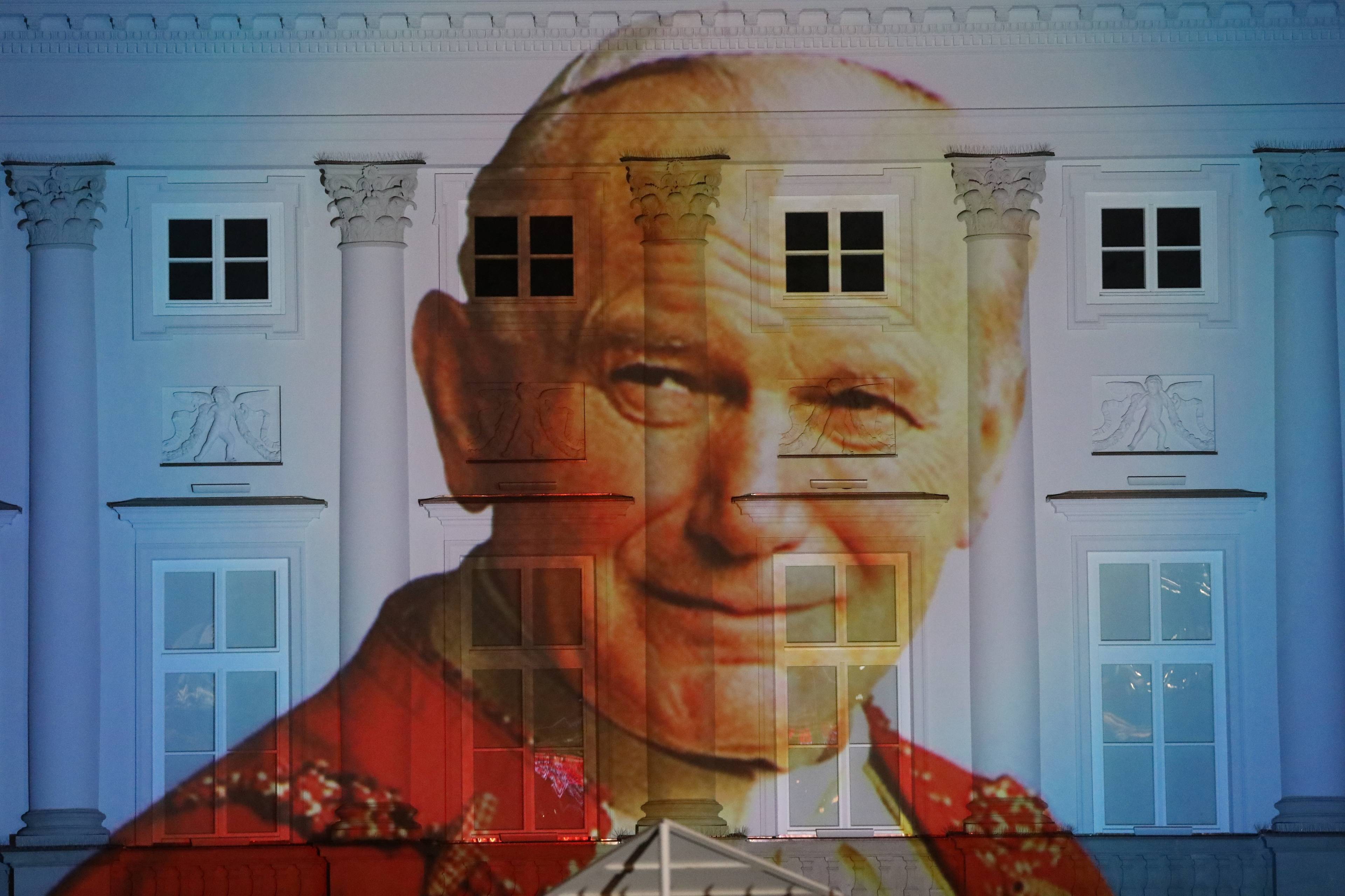 Portret Jana Pawła II wyświetlony na budynku z półkolumnami