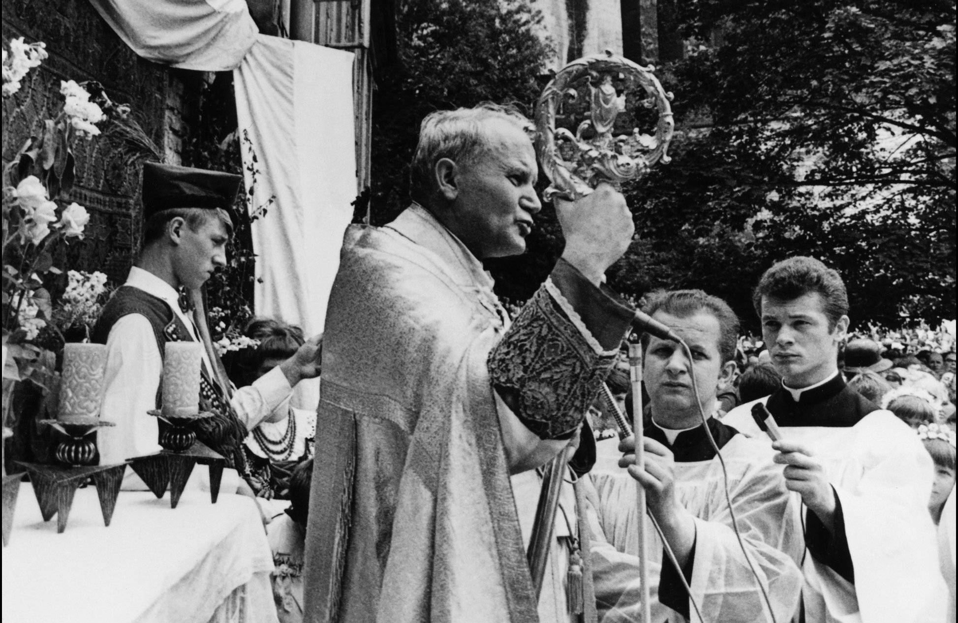 czarno niałe zdjęcie przedstawiające Karola Wojtyłę podczas odprawiania mszy na świeżym powietrzu w Krakowie