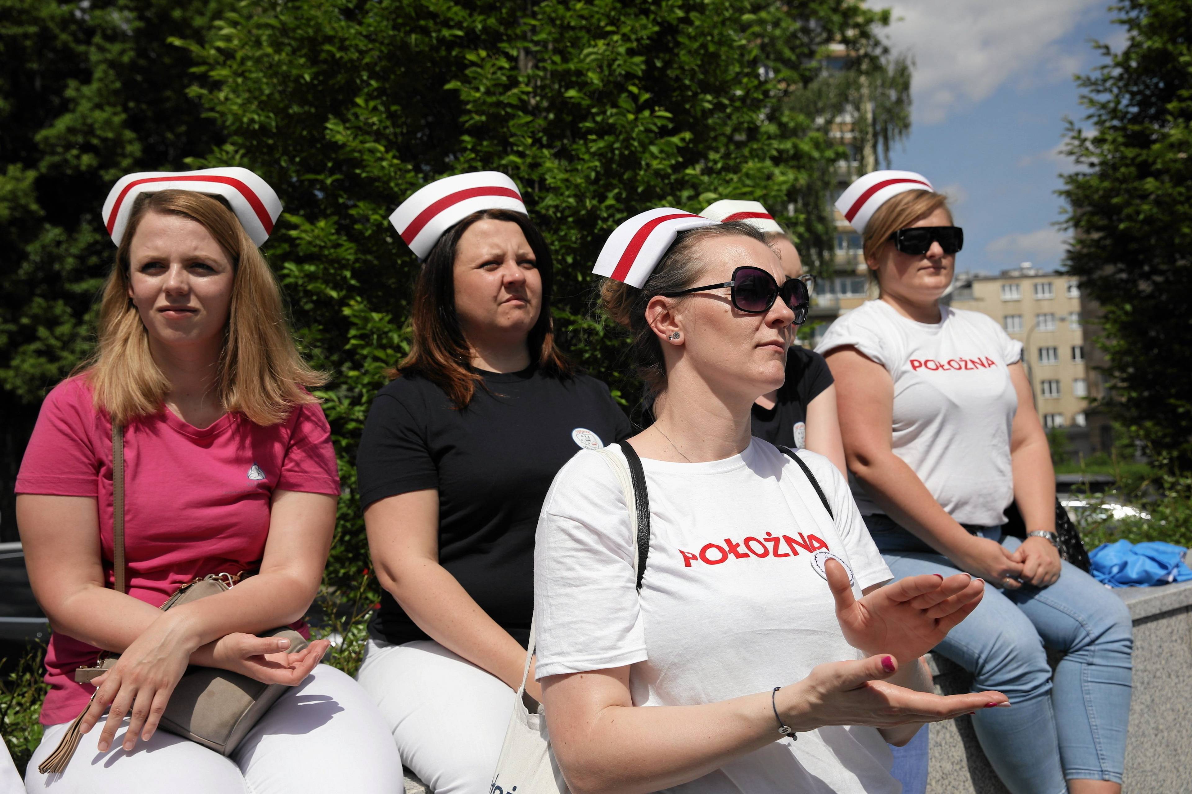 Pielęgniarki w służbowych strojach stoją przed Sejmem i domagają się swoich praw