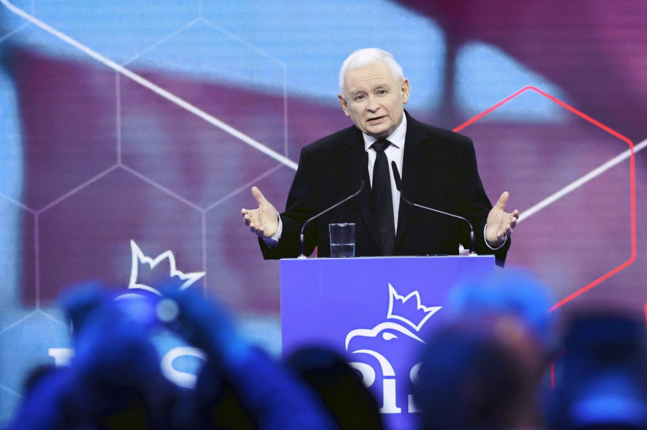 Jarosław Kaczyński z rozłożonymi rękami przemawia za mównicą na oficjalnej partyjnej konwencji PiS