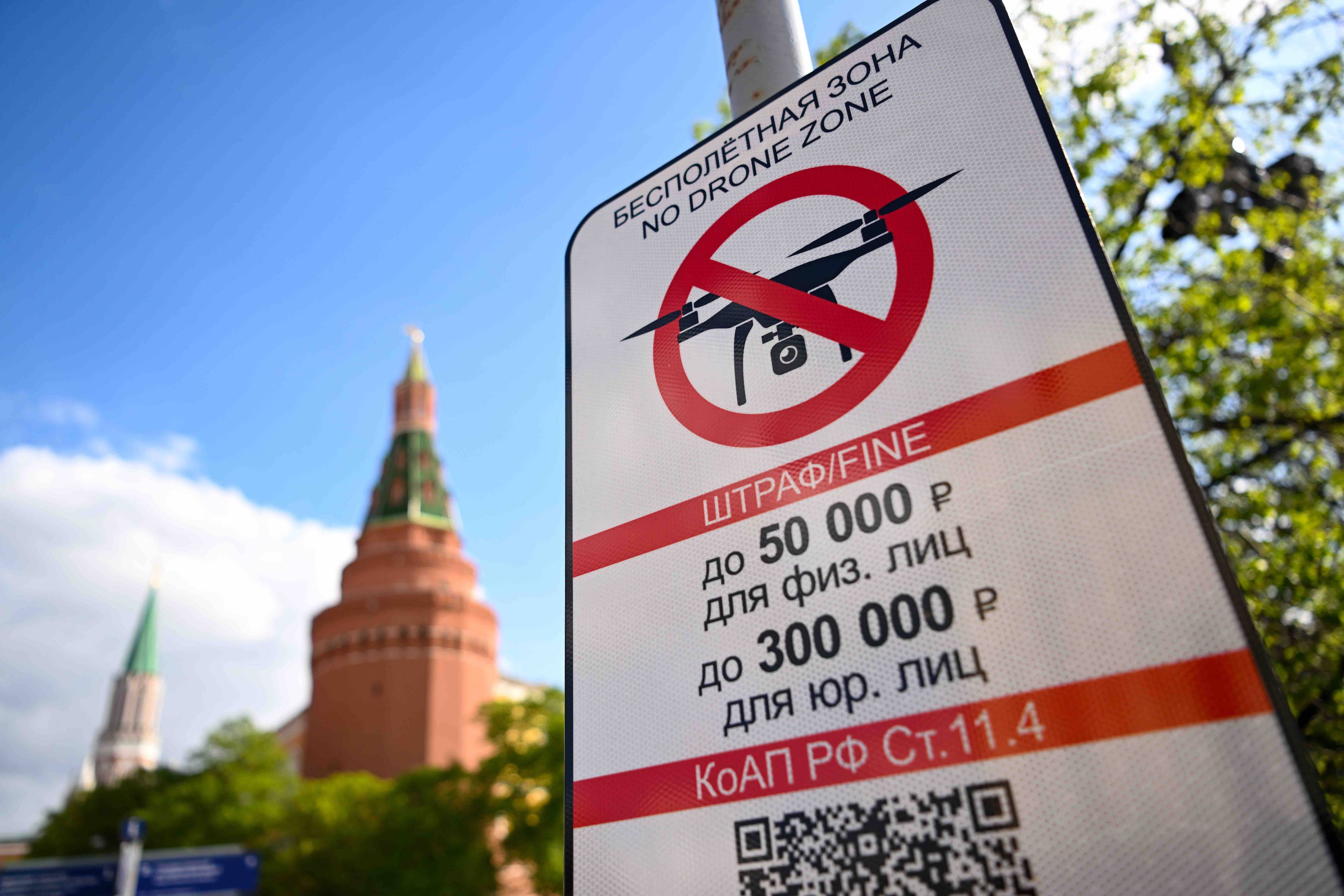 znak zakazu lotow dronami umieszczony na słupie, w tle wieże Kremla
