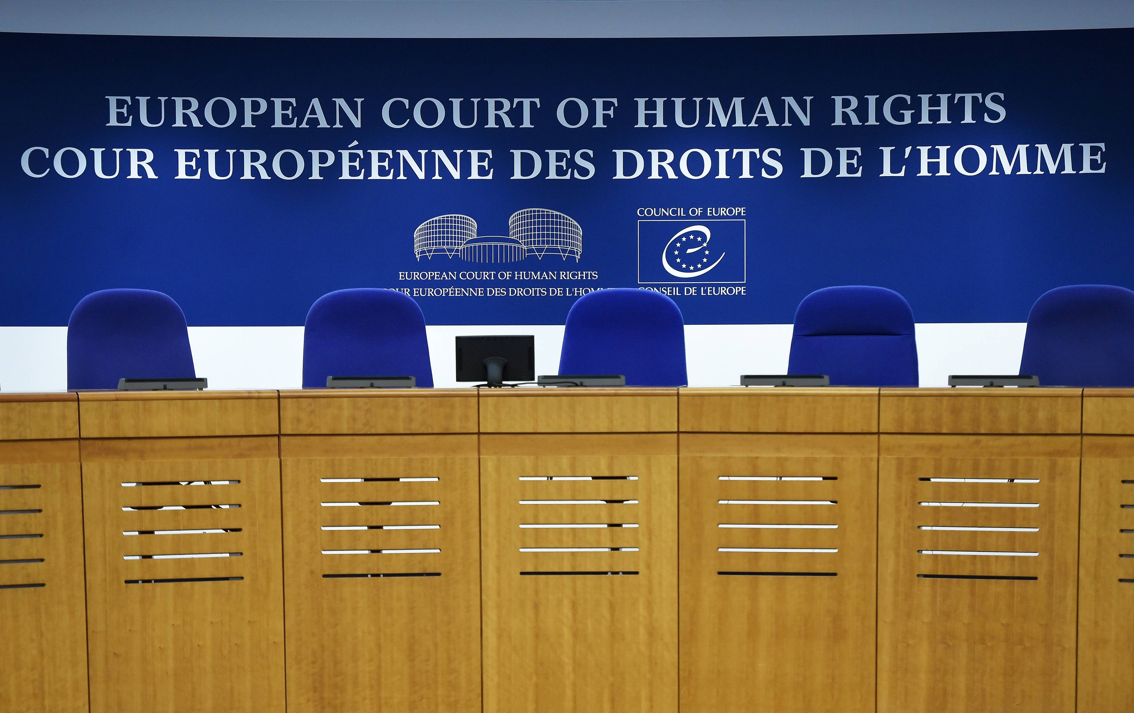 Miescja dla sędziów za stołem trynunału. Na górze angielski i francuskie napis: Europejski Trybunał Praw Człowieka