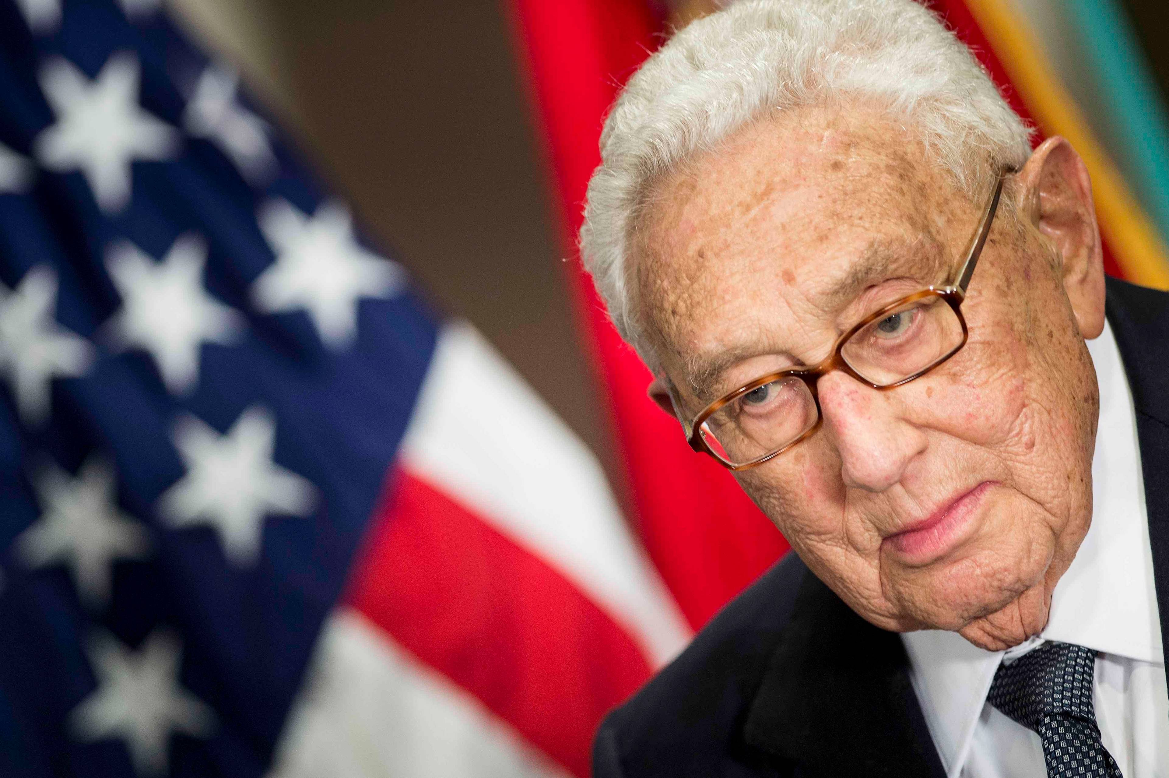 Portret Henry'ego Kissingera na tle amerykańskiej flagi