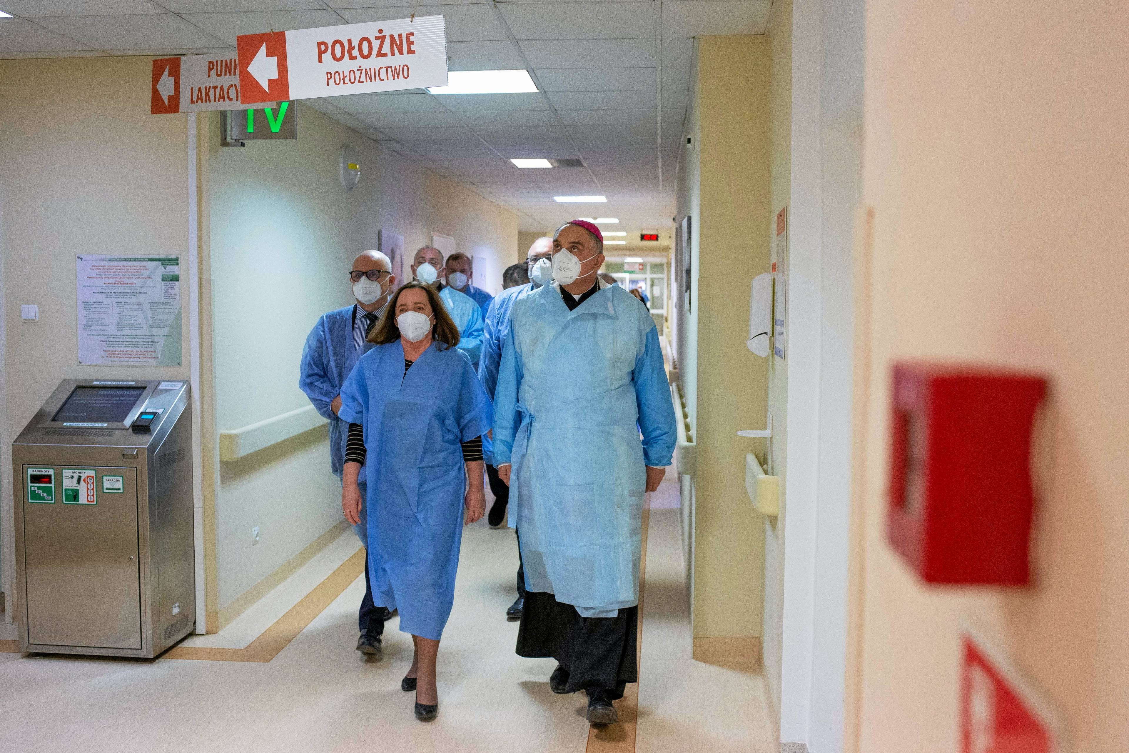 Ksiądz w maseczce i kitlu zwiedza oddział położniczy w szpitalu w Bydgoszczy